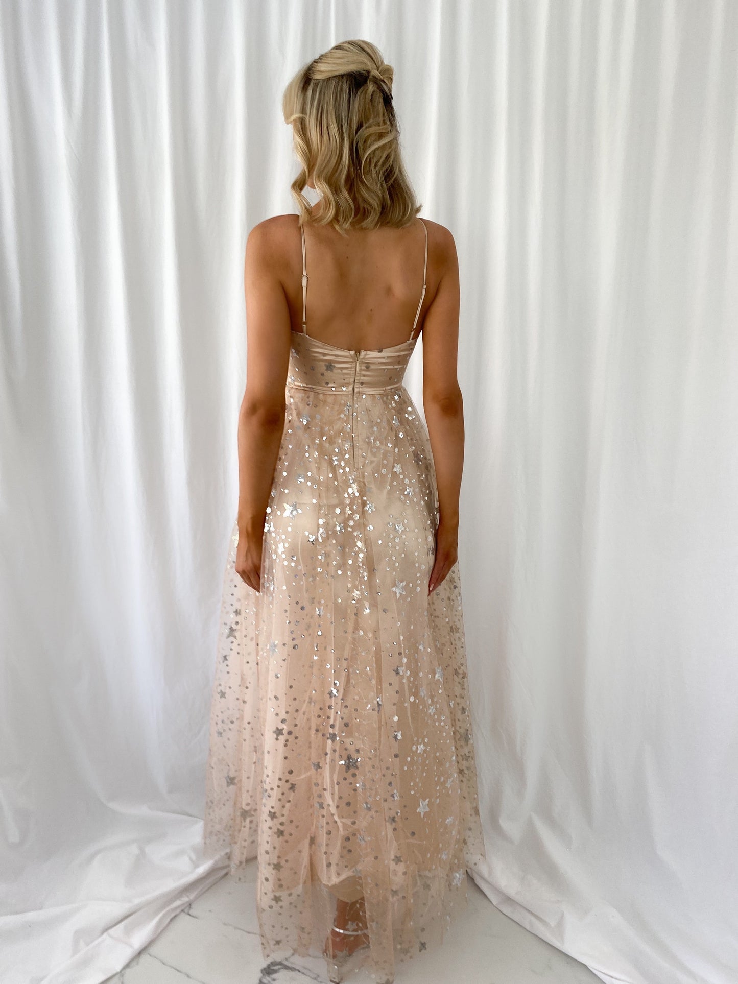 a woman in a dress standing next to a large statue