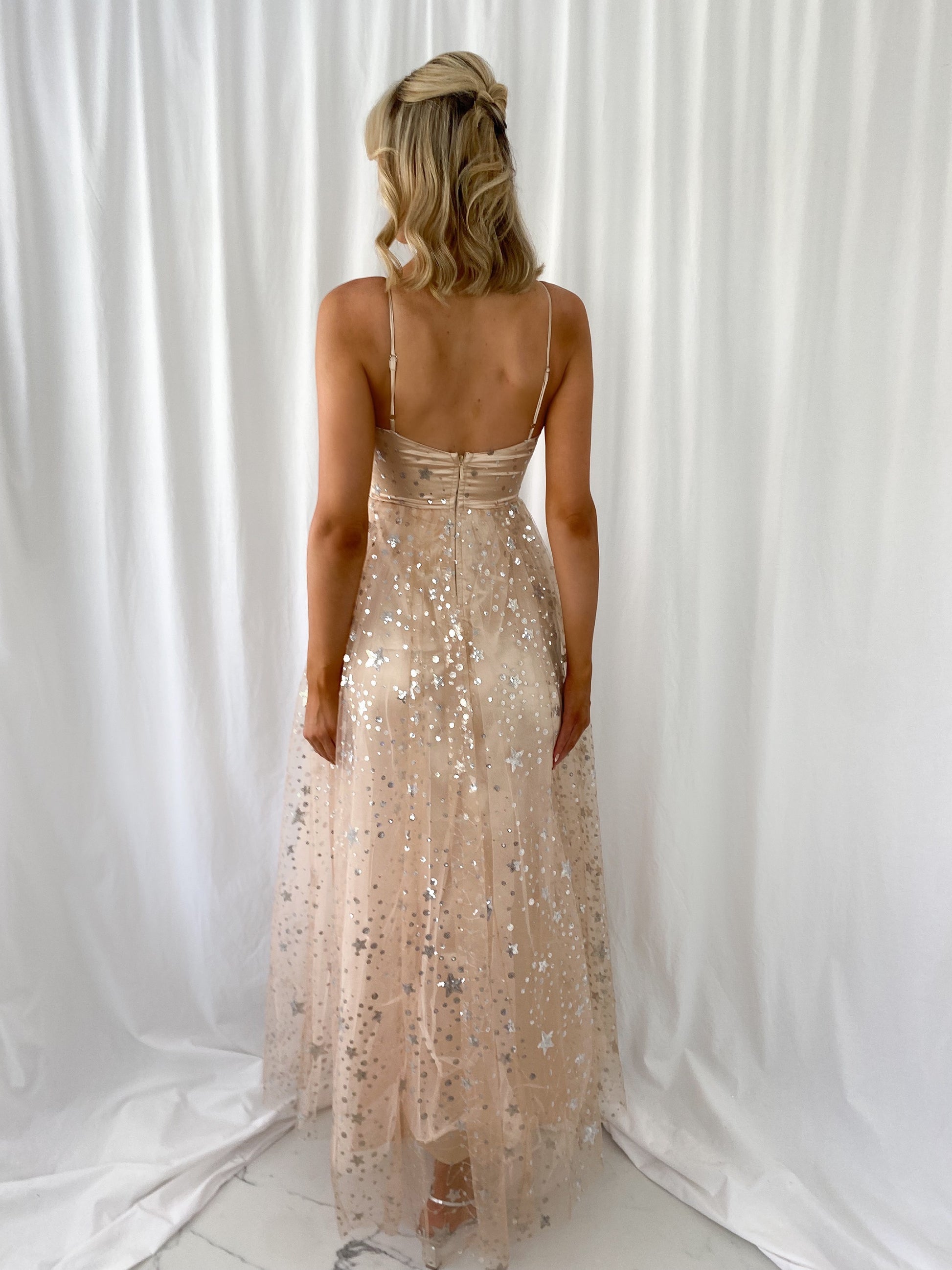 a woman in a dress standing next to a large statue