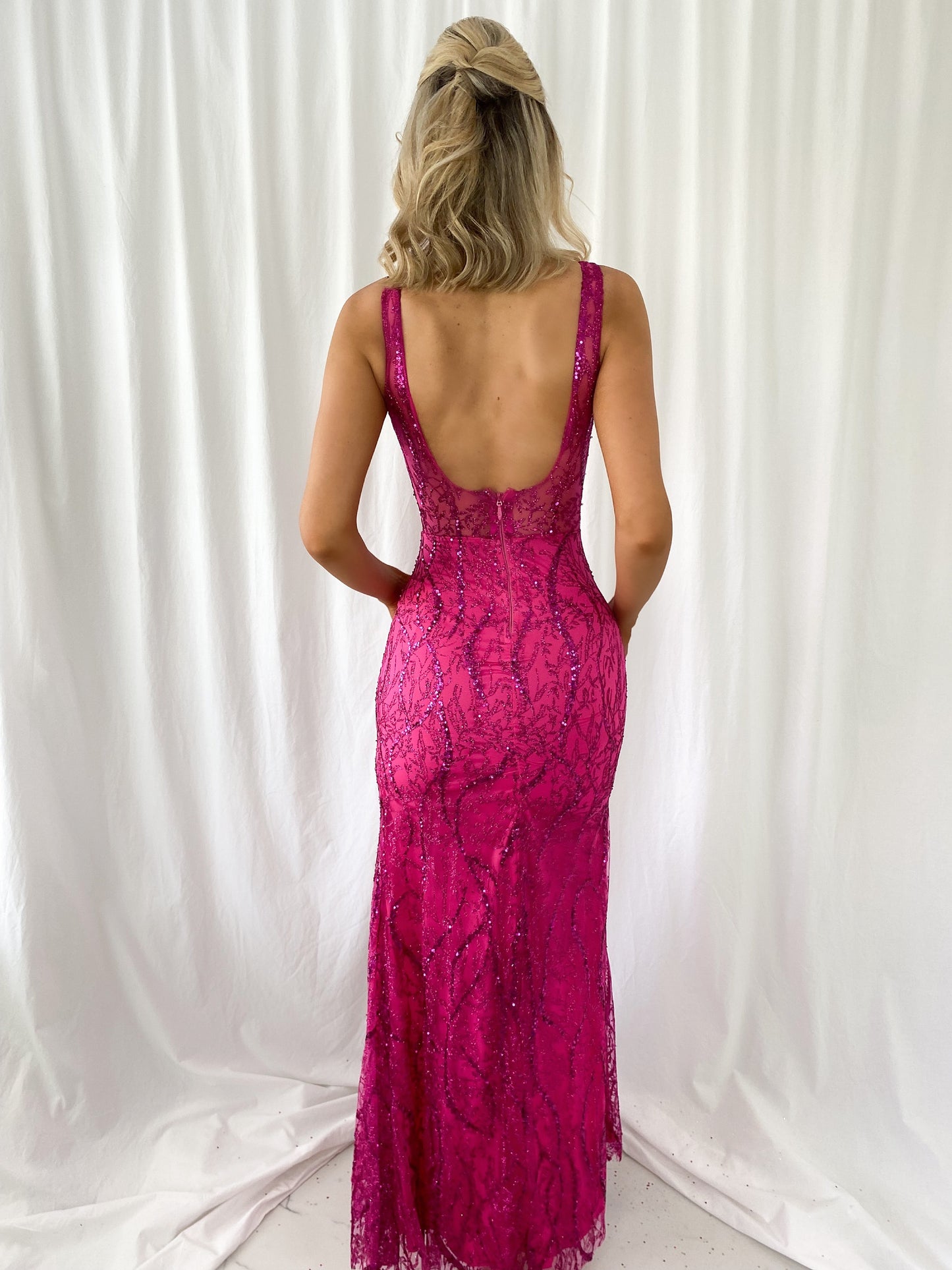 a woman in a pink dress holding a cell phone