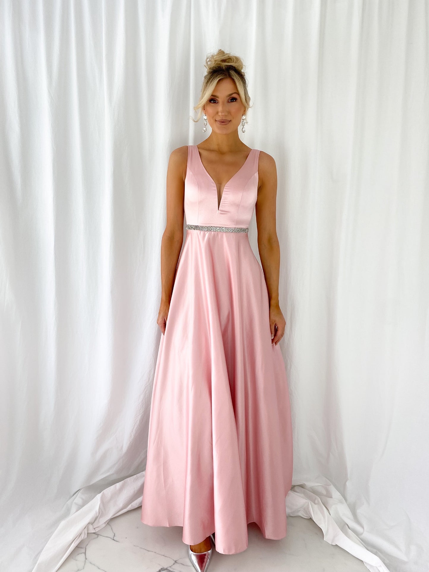 a woman in a pink dress standing in a white dress