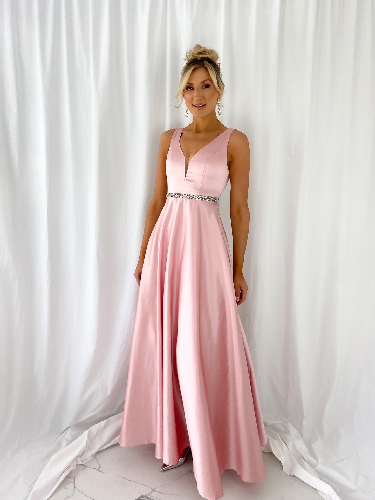 a woman in a pink dress standing in a white dress