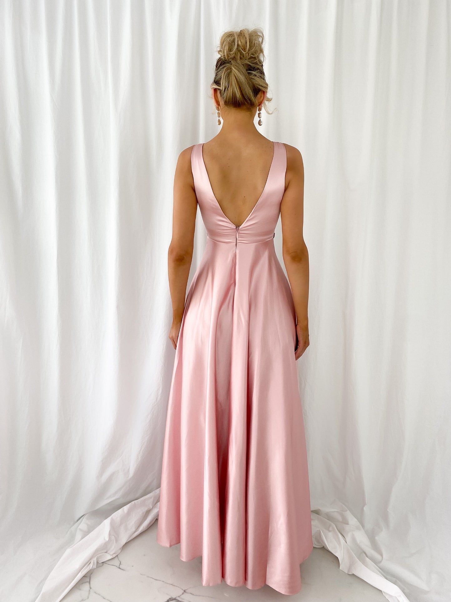 a woman in a pink dress standing in a white dress