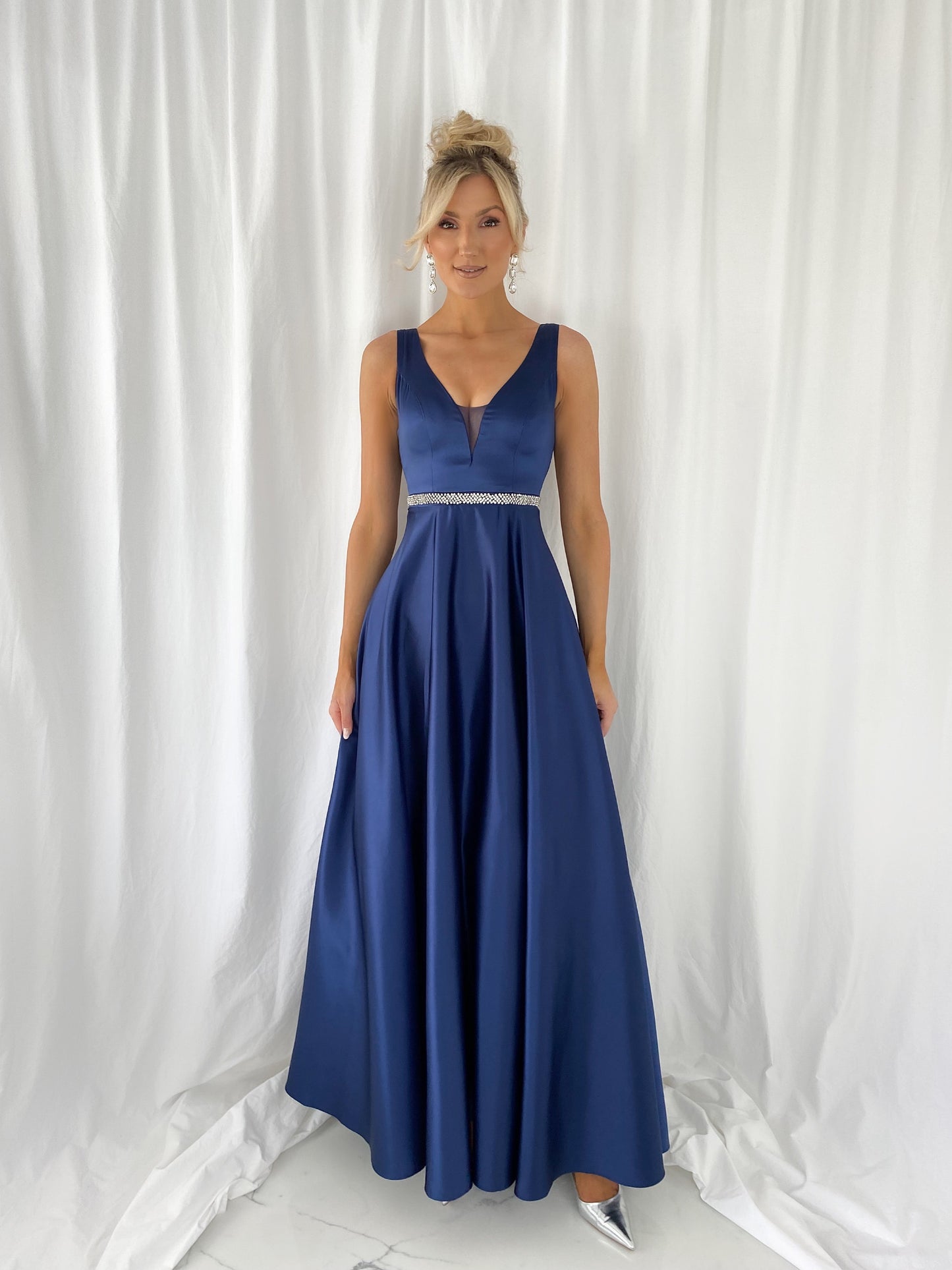 a woman in a blue dress standing in a white dress