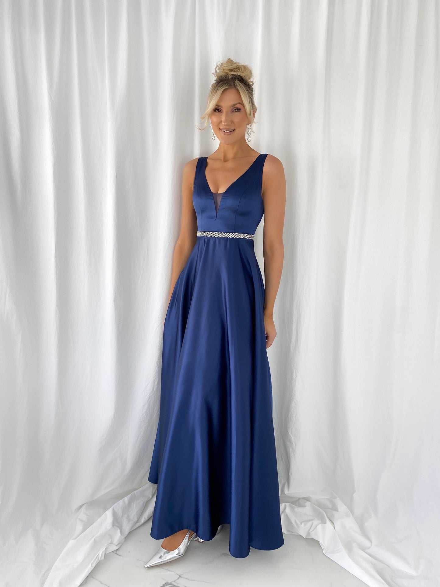 a woman in a blue dress talking on a cell phone