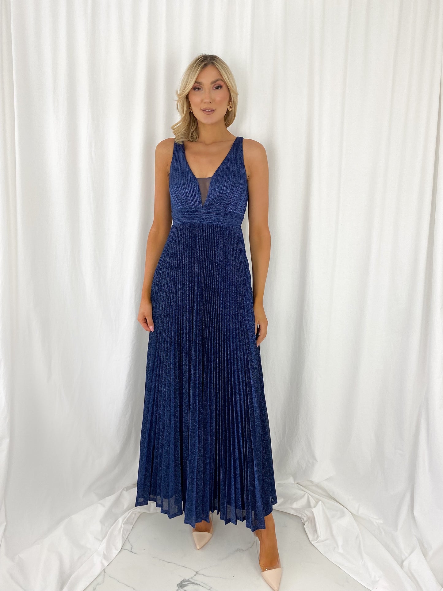 a woman in a blue dress standing in a white dress