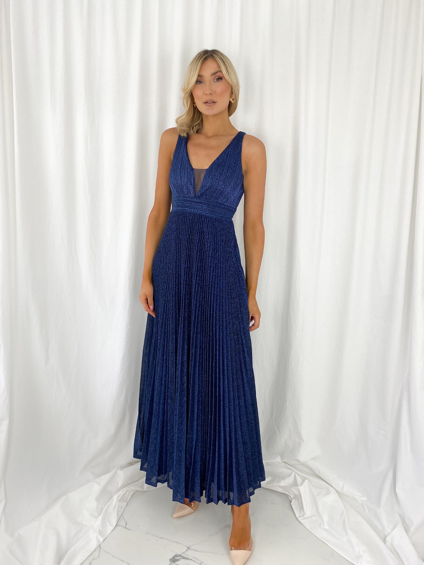 a woman in a blue dress standing in a white dress