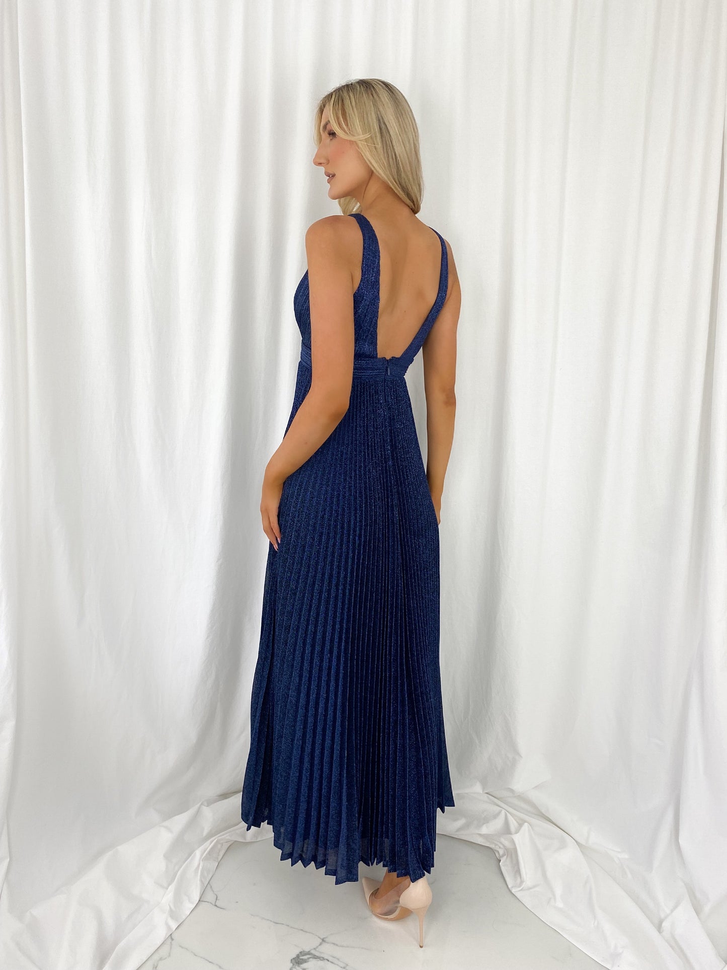 a woman in a blue dress talking on a cell phone