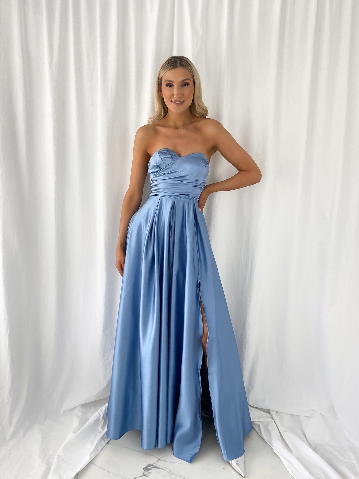 a woman in a blue dress standing in a white dress