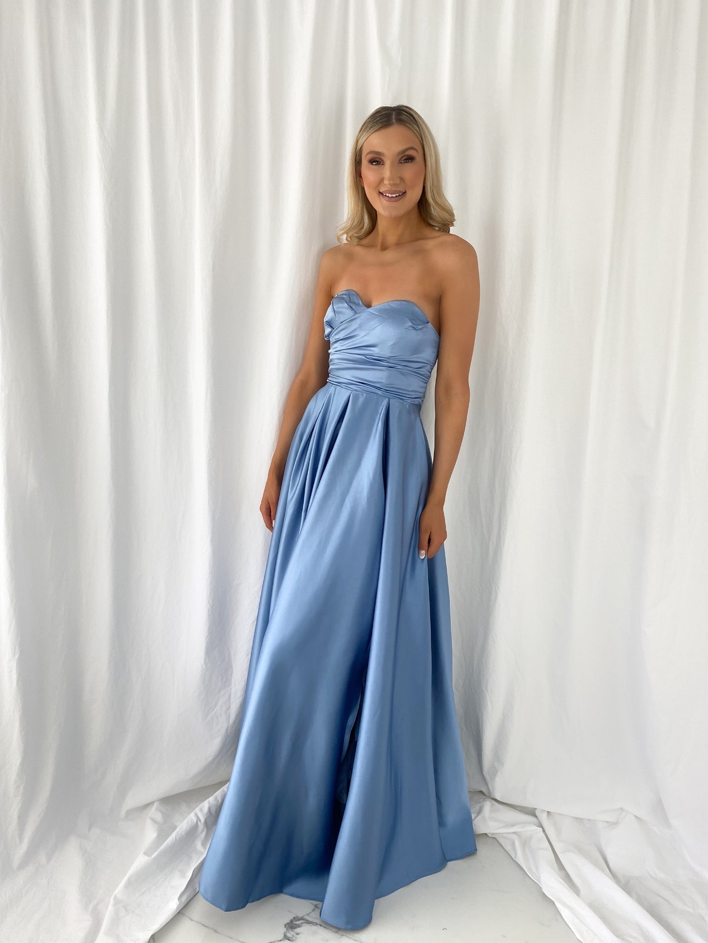 a woman in a blue dress standing in a white dress