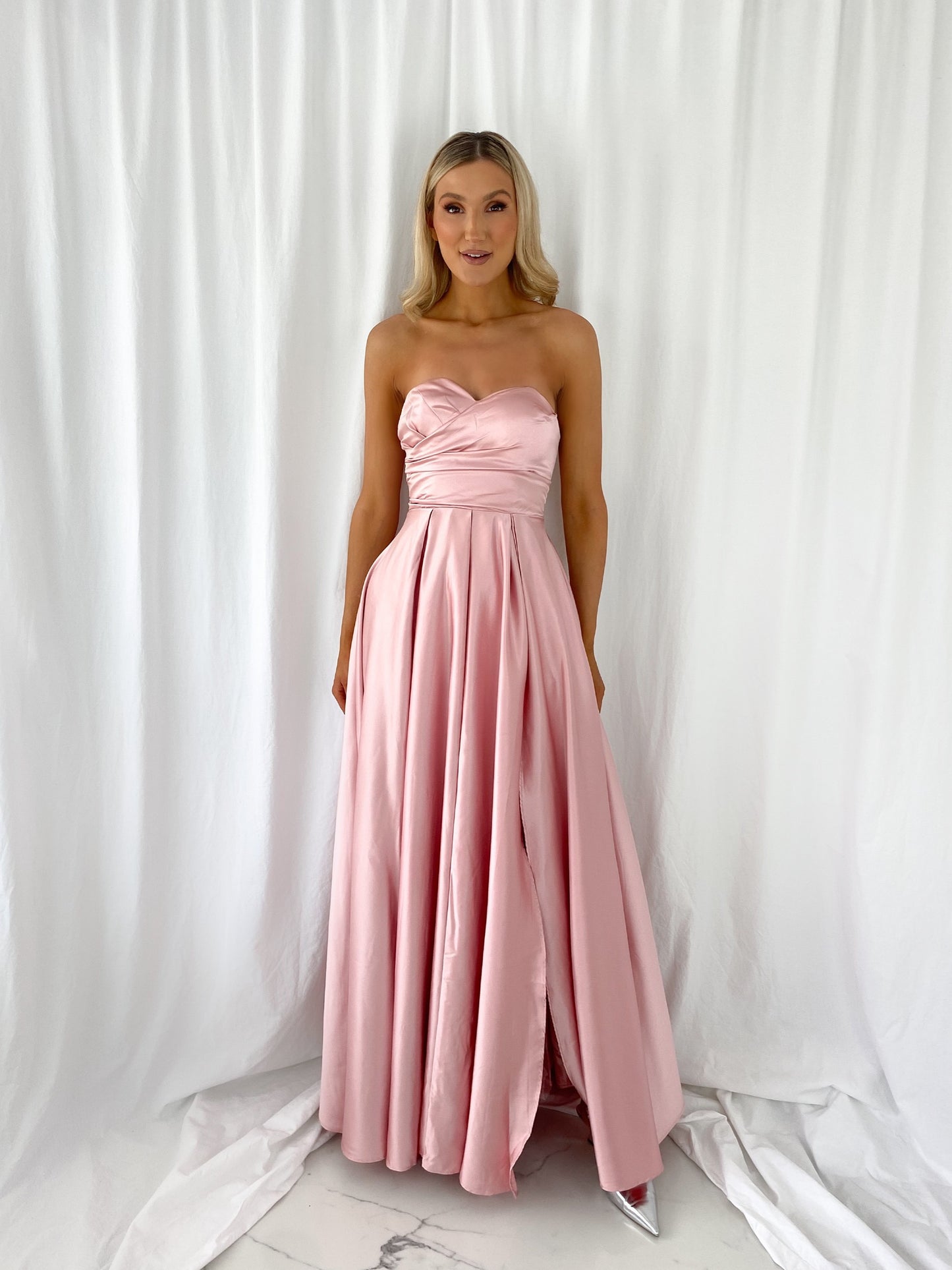 a woman in a pink dress holding a pink dress