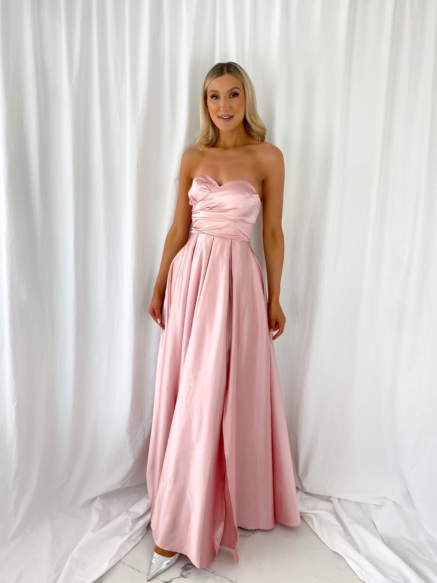 a woman in a pink dress standing in a white dress