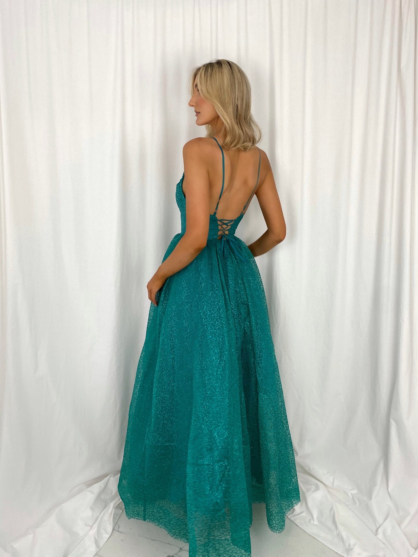 a woman in a dress is talking on a cell phone