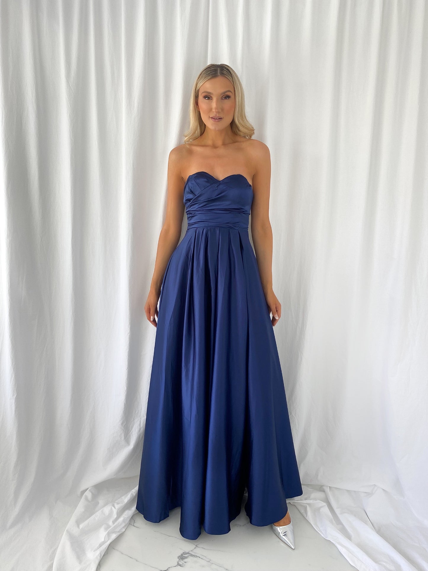 a woman in a blue dress standing in a white dress