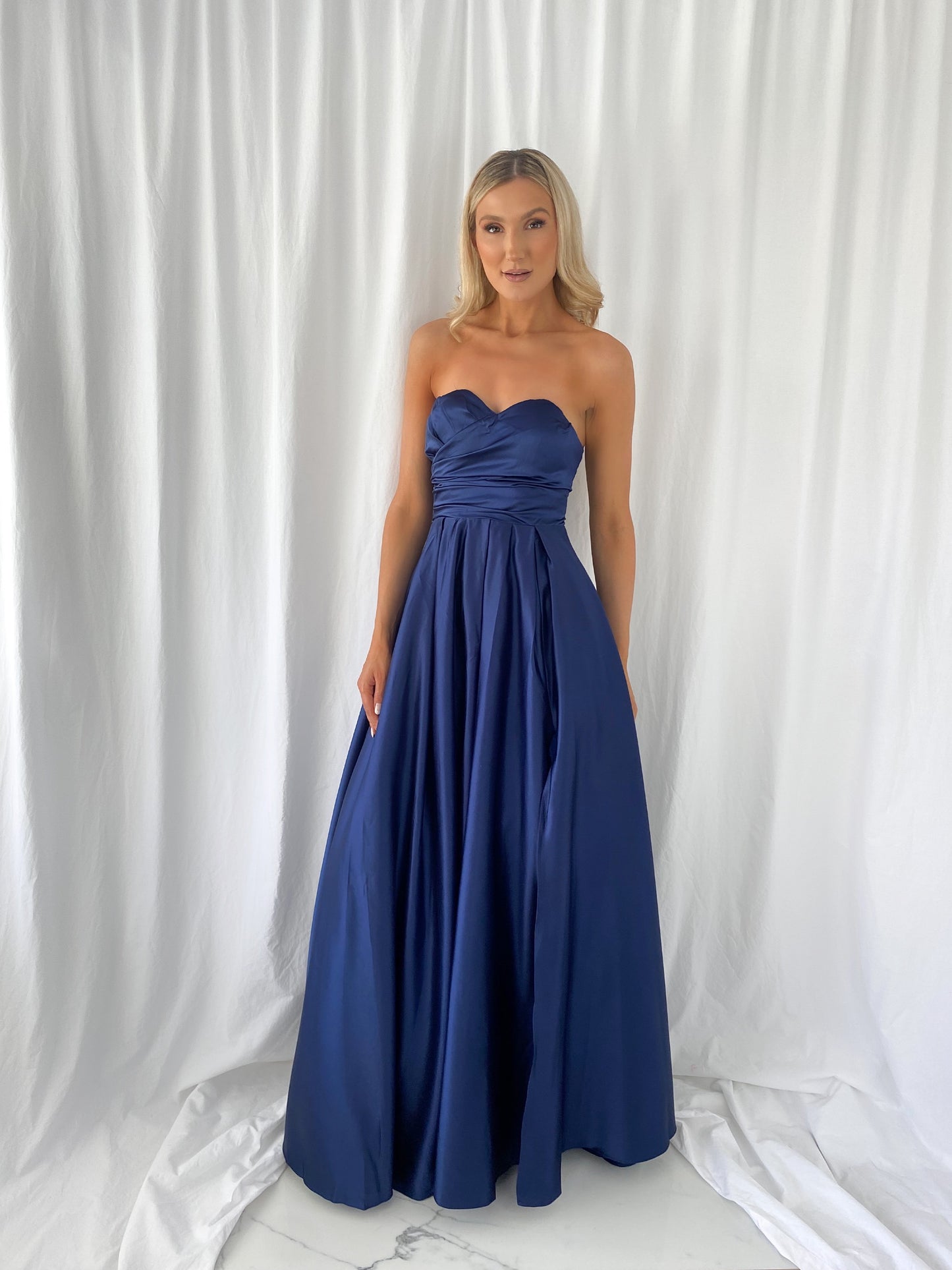 a woman in a blue dress standing in a white dress