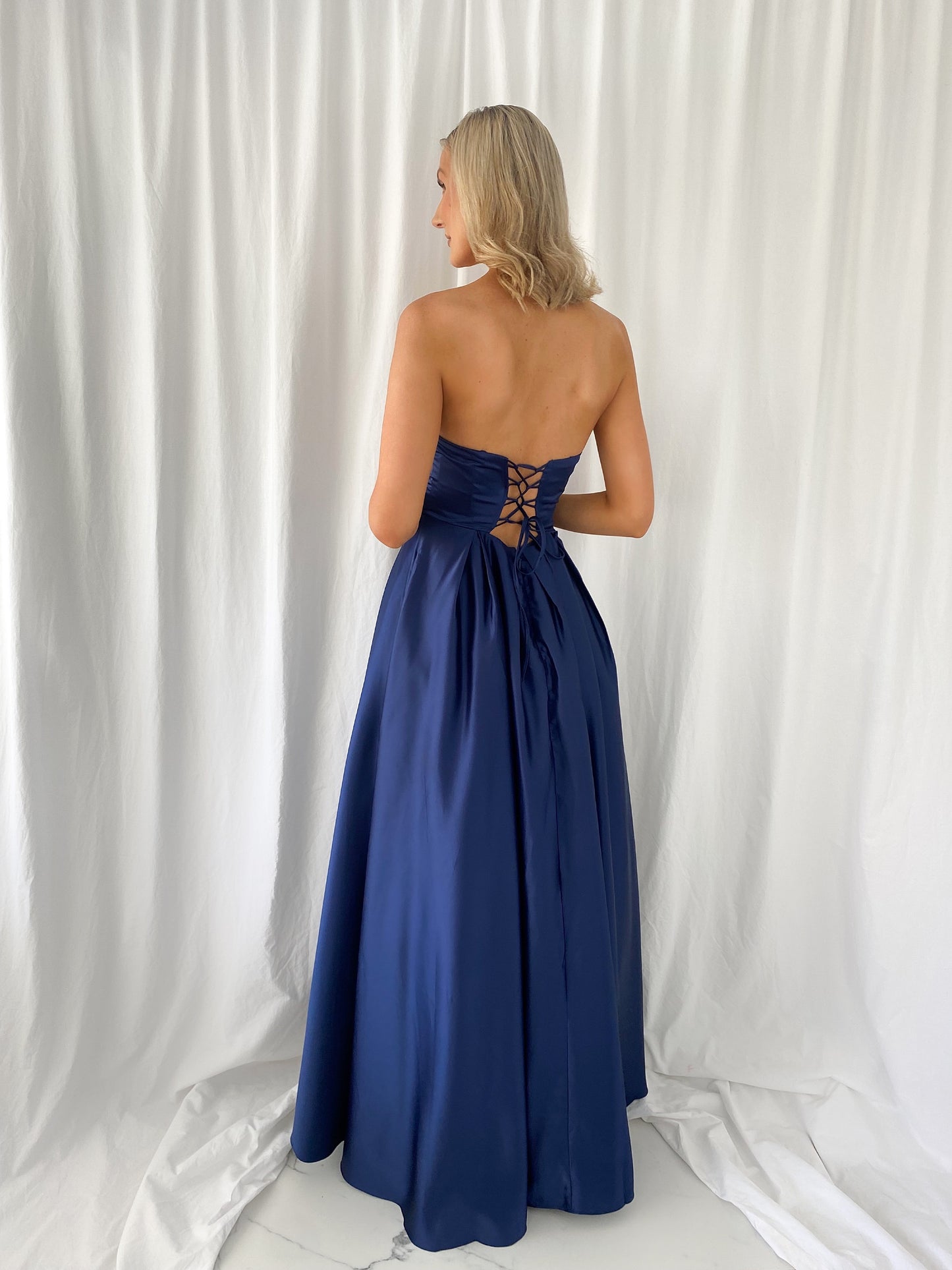 a woman in a blue dress standing in a white dress