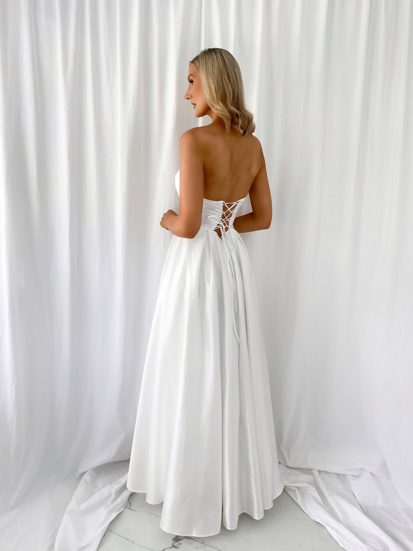 a woman in a white dress standing in a white dress