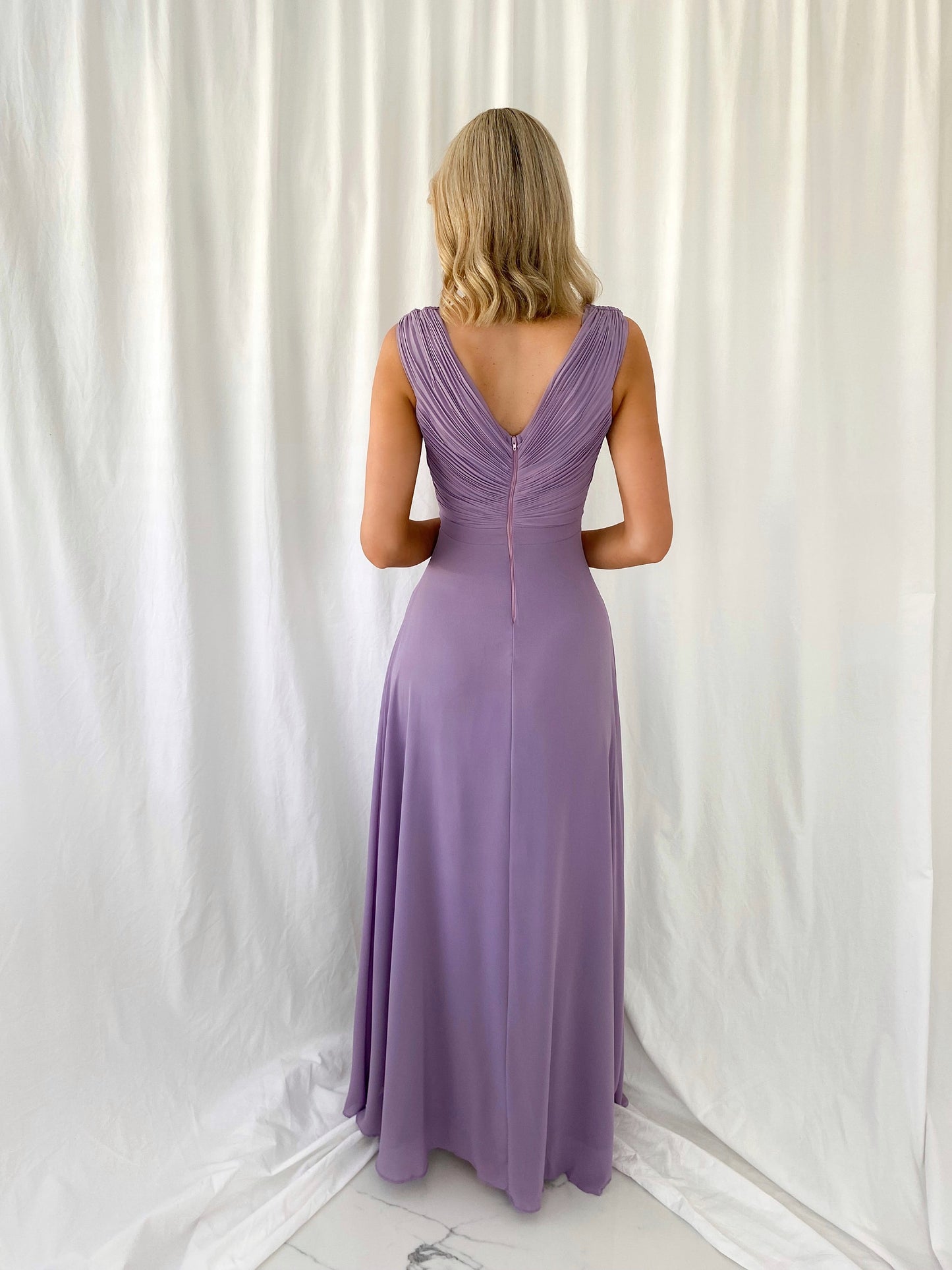 a woman in a pink dress is holding a cell phone