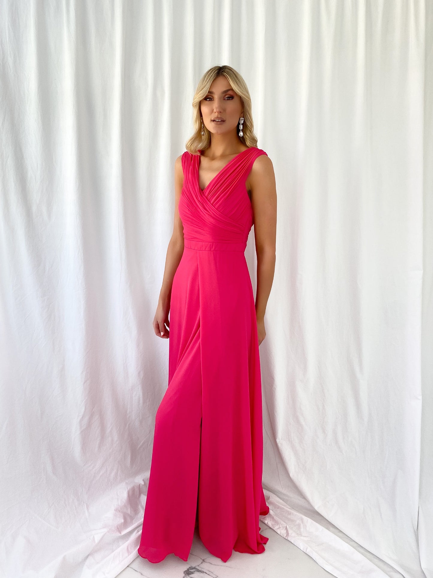 a woman in a red dress talking on a cell phone 