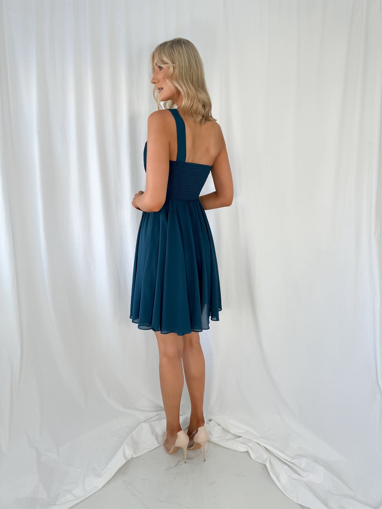 a woman in a dress talking on a cell phone