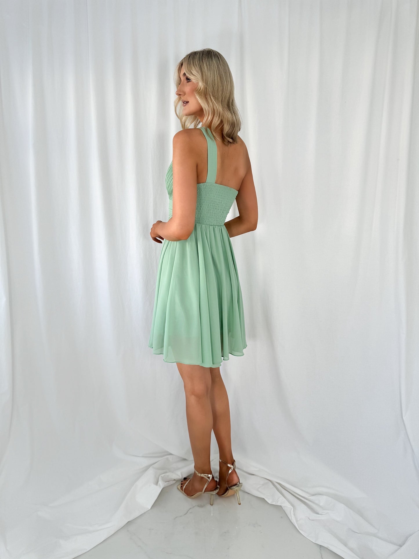 a woman in a dress standing on a bed