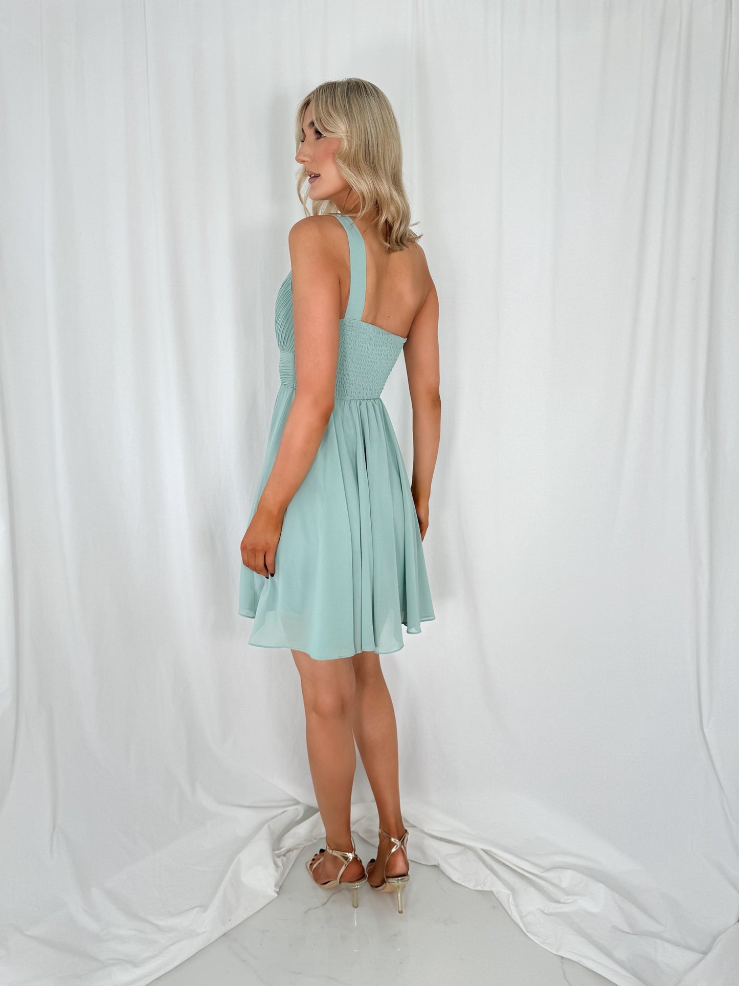 a woman in a dress standing on a bed