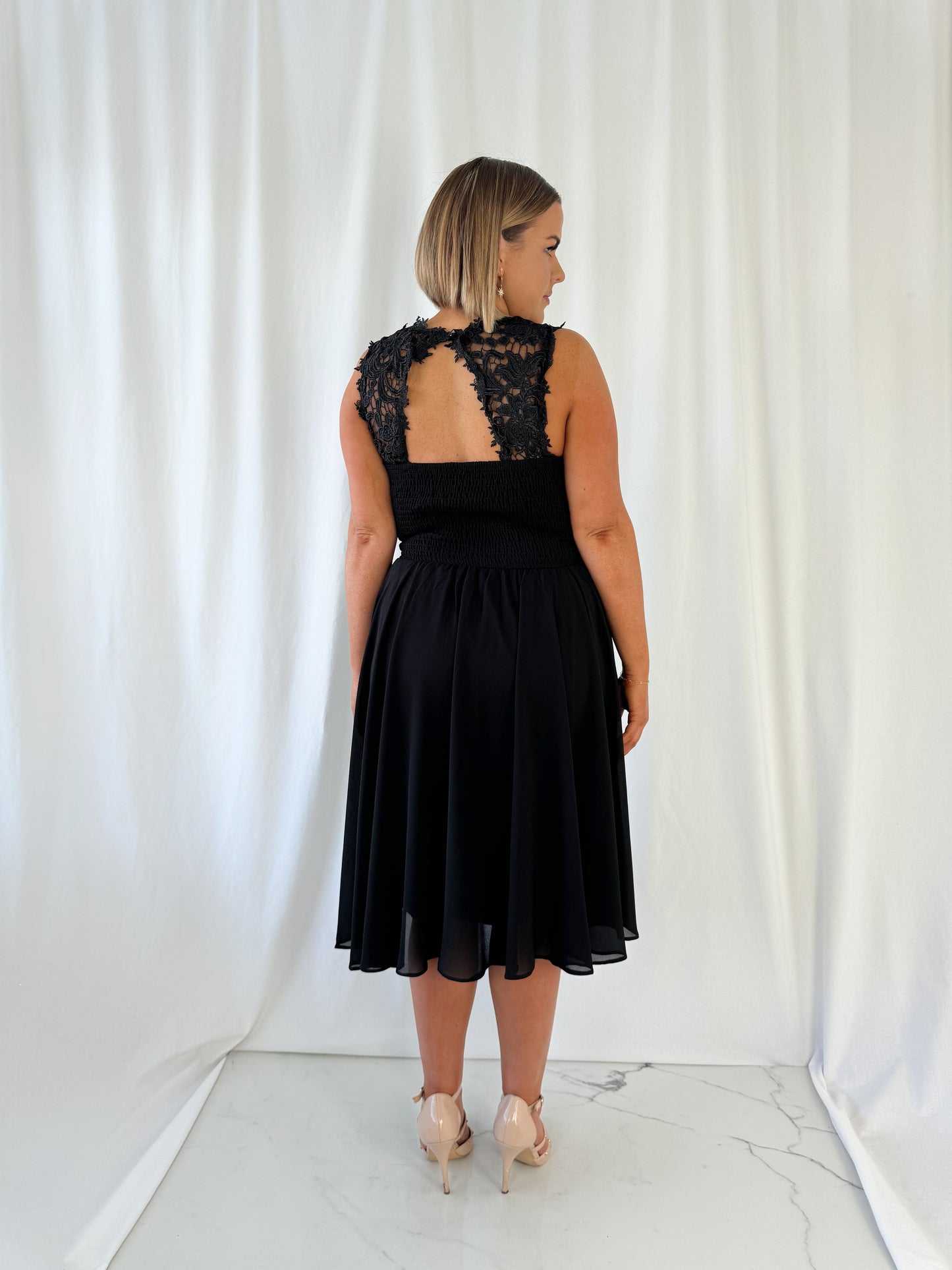 a woman in a dress is talking on a cell phone