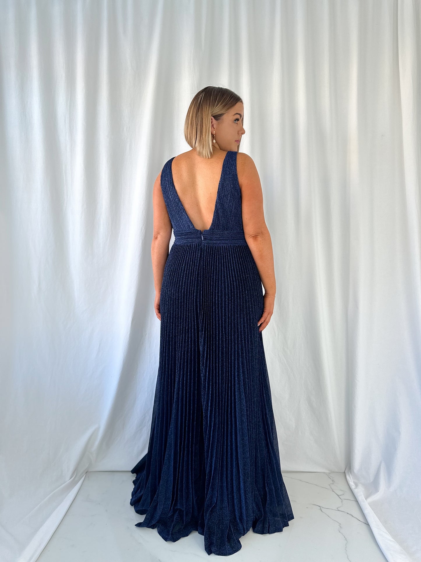 a woman in a white dress talking on a cell phone