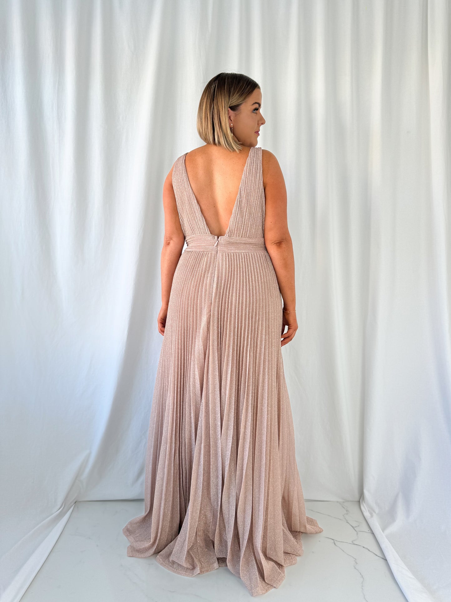 a woman in a white dress talking on a cell phone