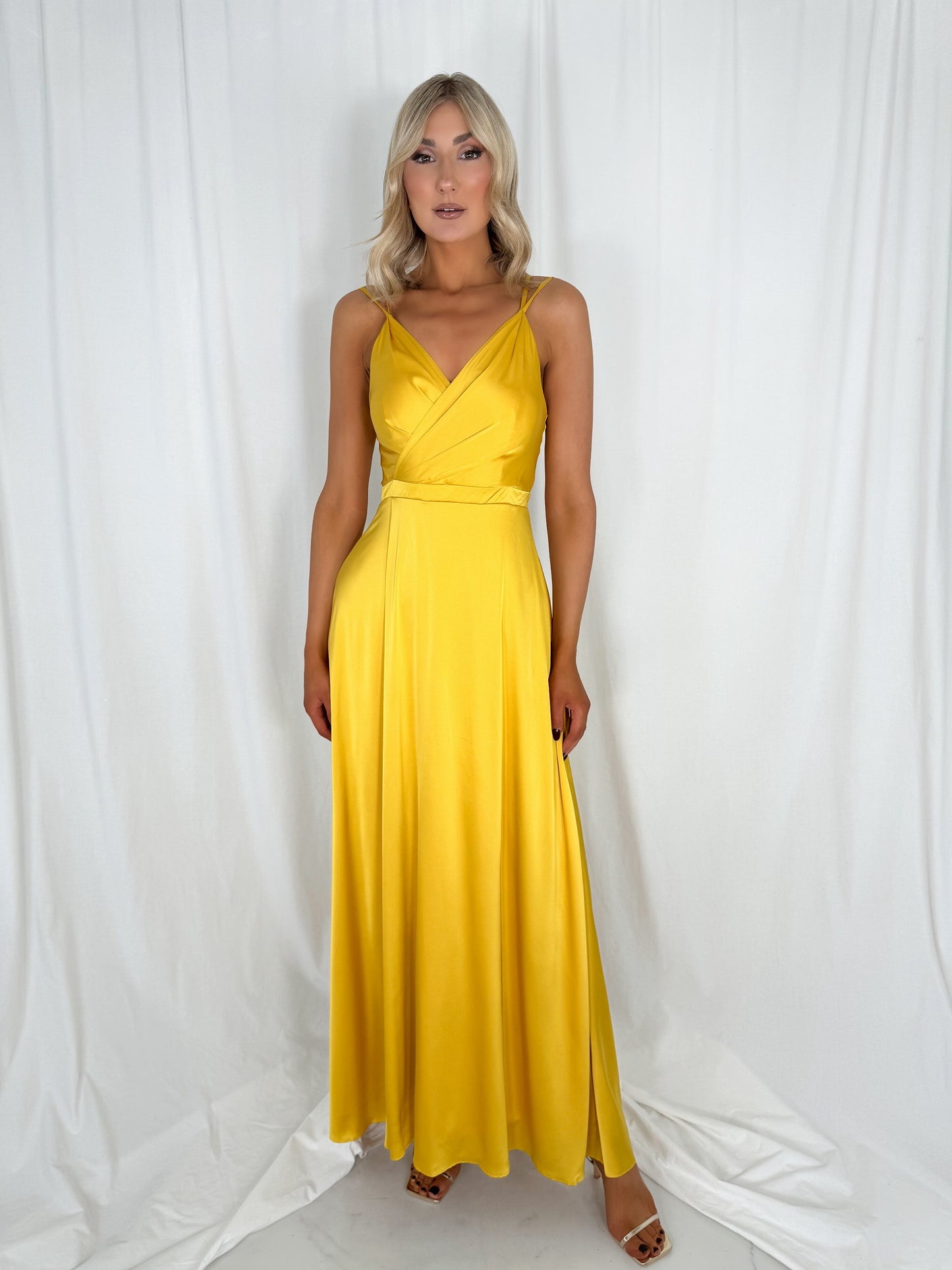 a woman in a yellow dress standing in a white dress