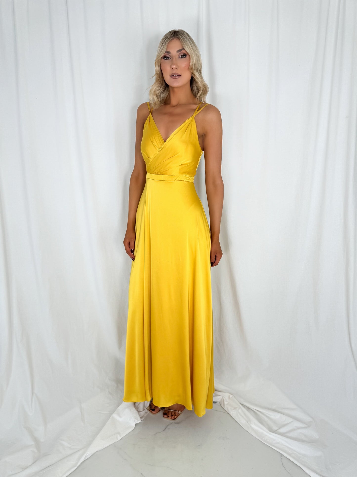 a woman in a yellow dress standing in a white dress
