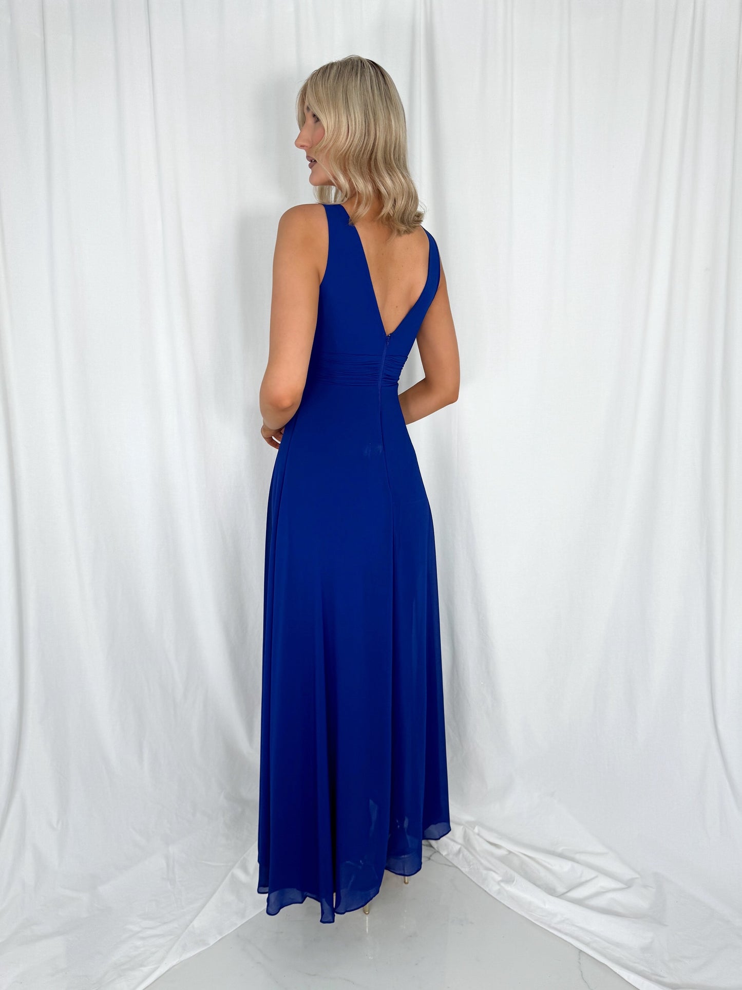 a woman in a blue dress talking on a cell phone