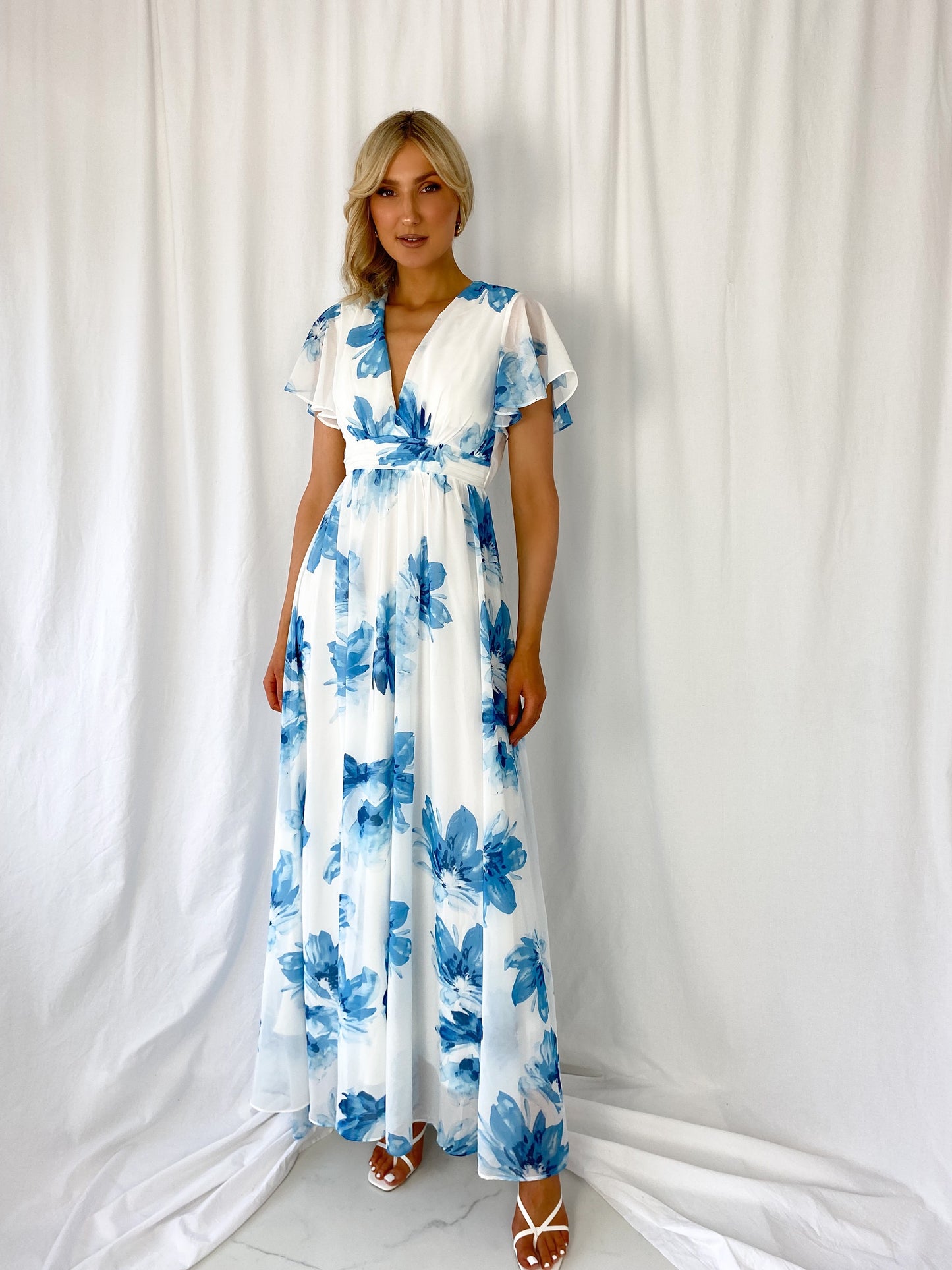 a woman in a blue dress holding a cell phone