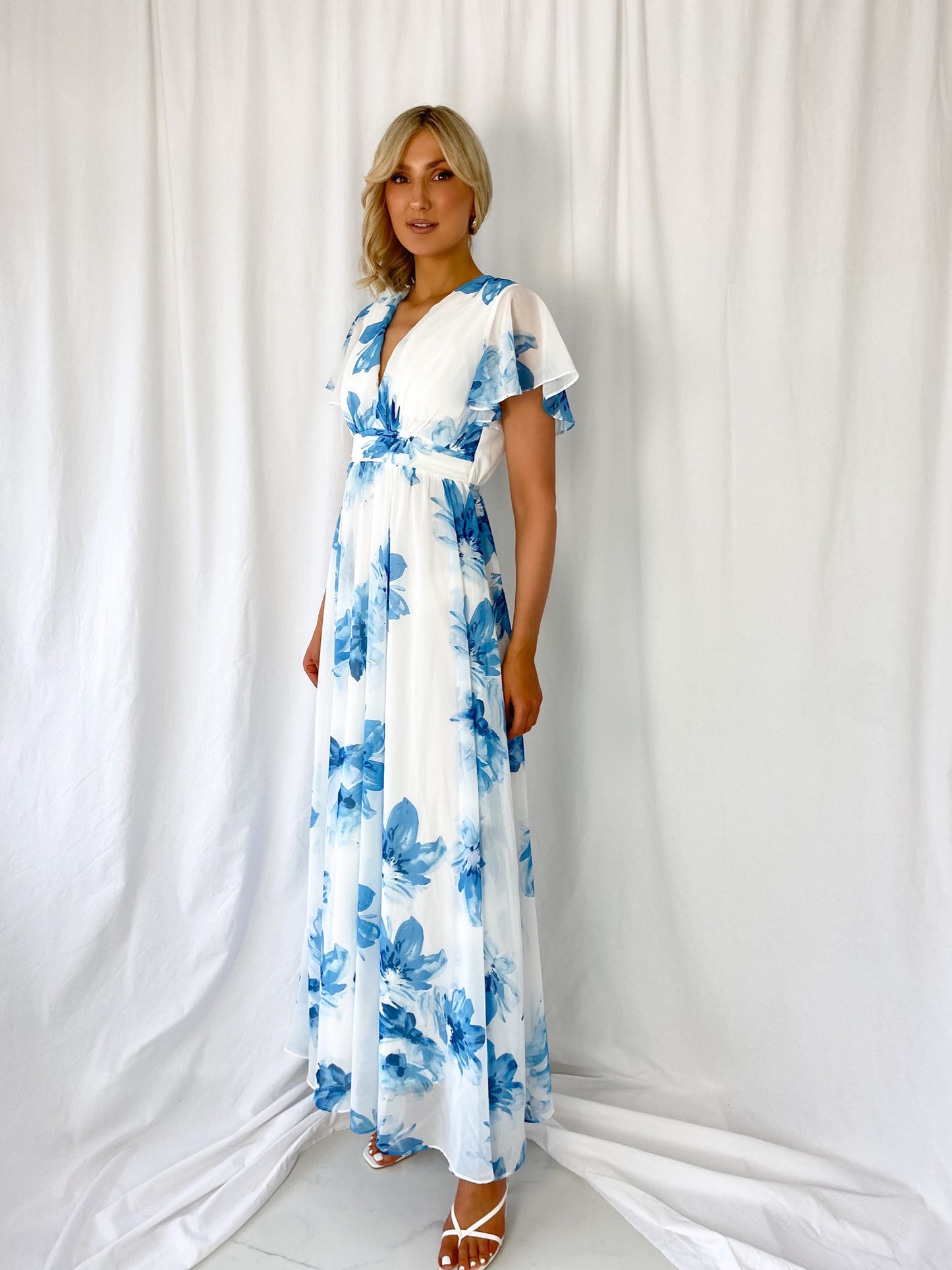 a woman in a blue dress holding a skateboard