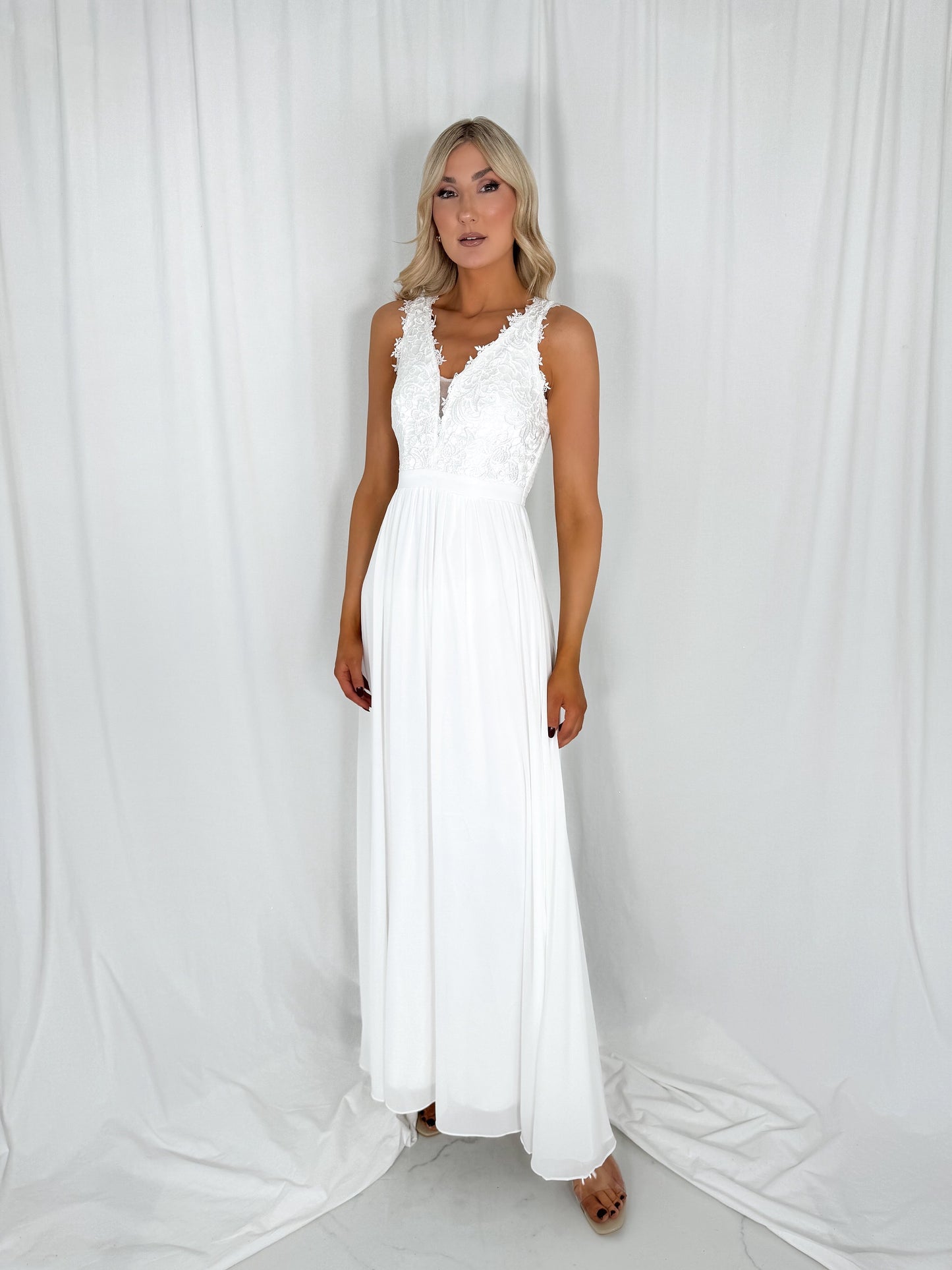 a woman in a white dress standing in a white dress