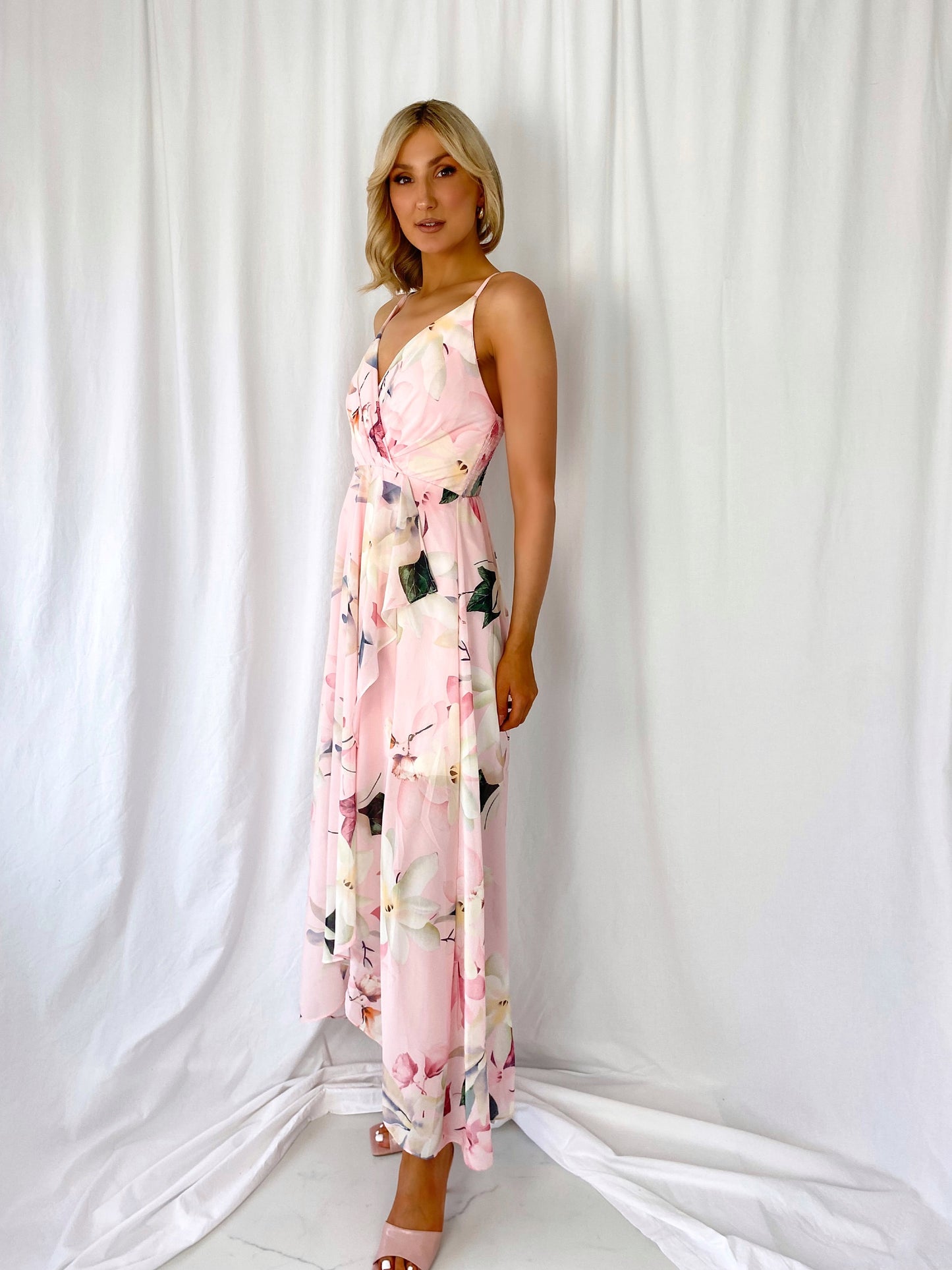 a woman in a pink dress holding a tennis racquet 