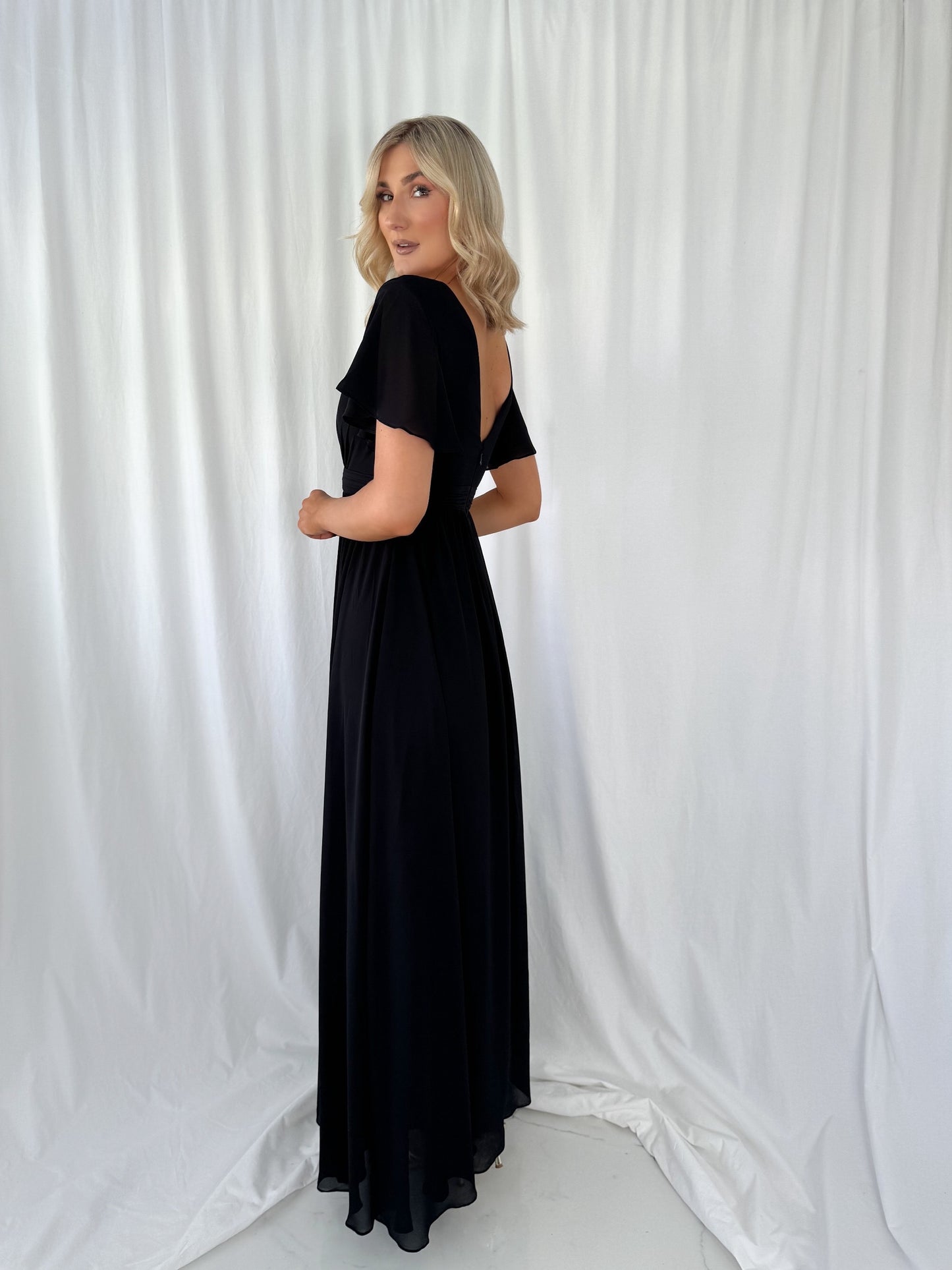a woman in a black dress standing in a white dress