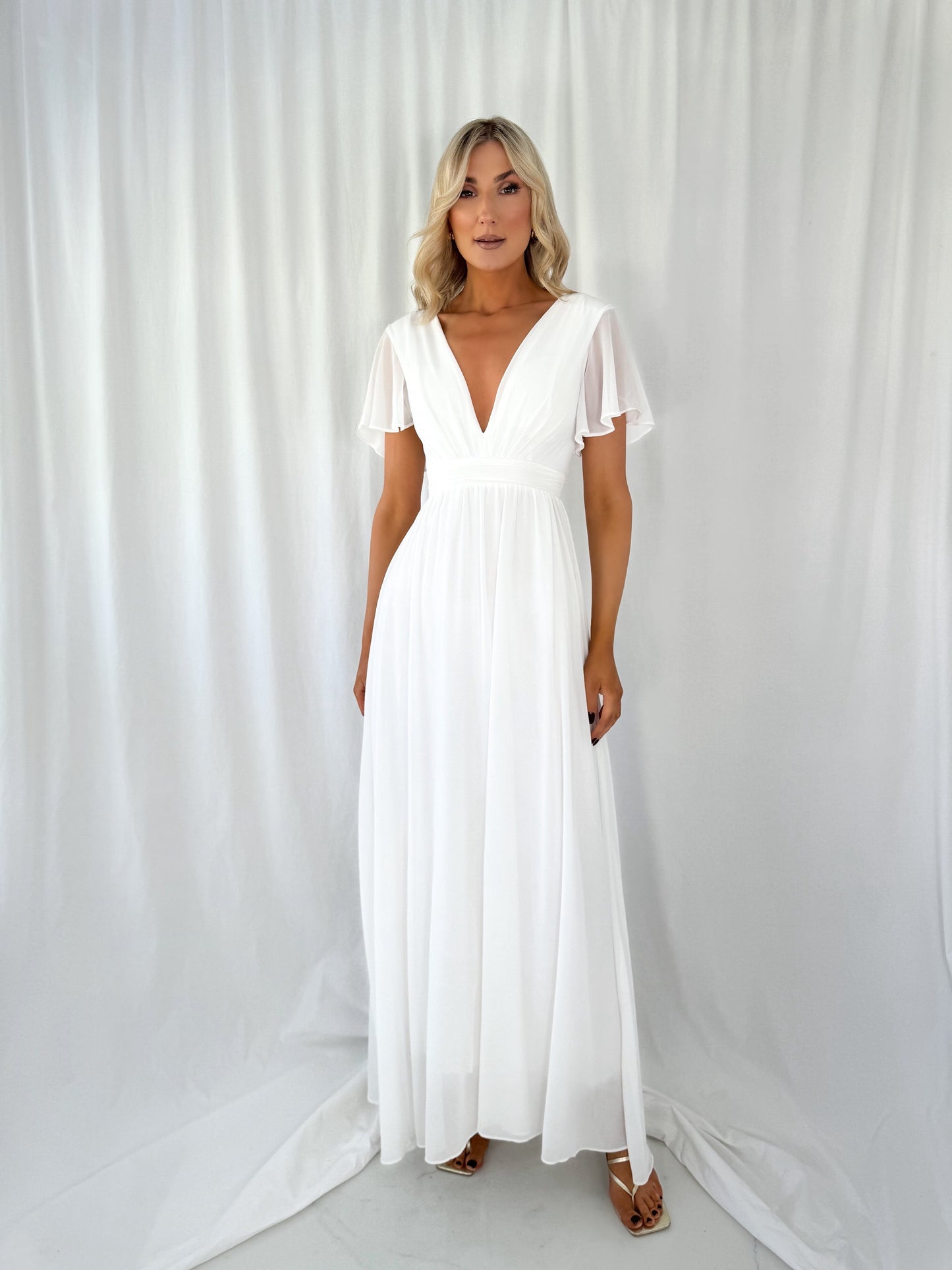 a woman in a white dress standing in a white dress