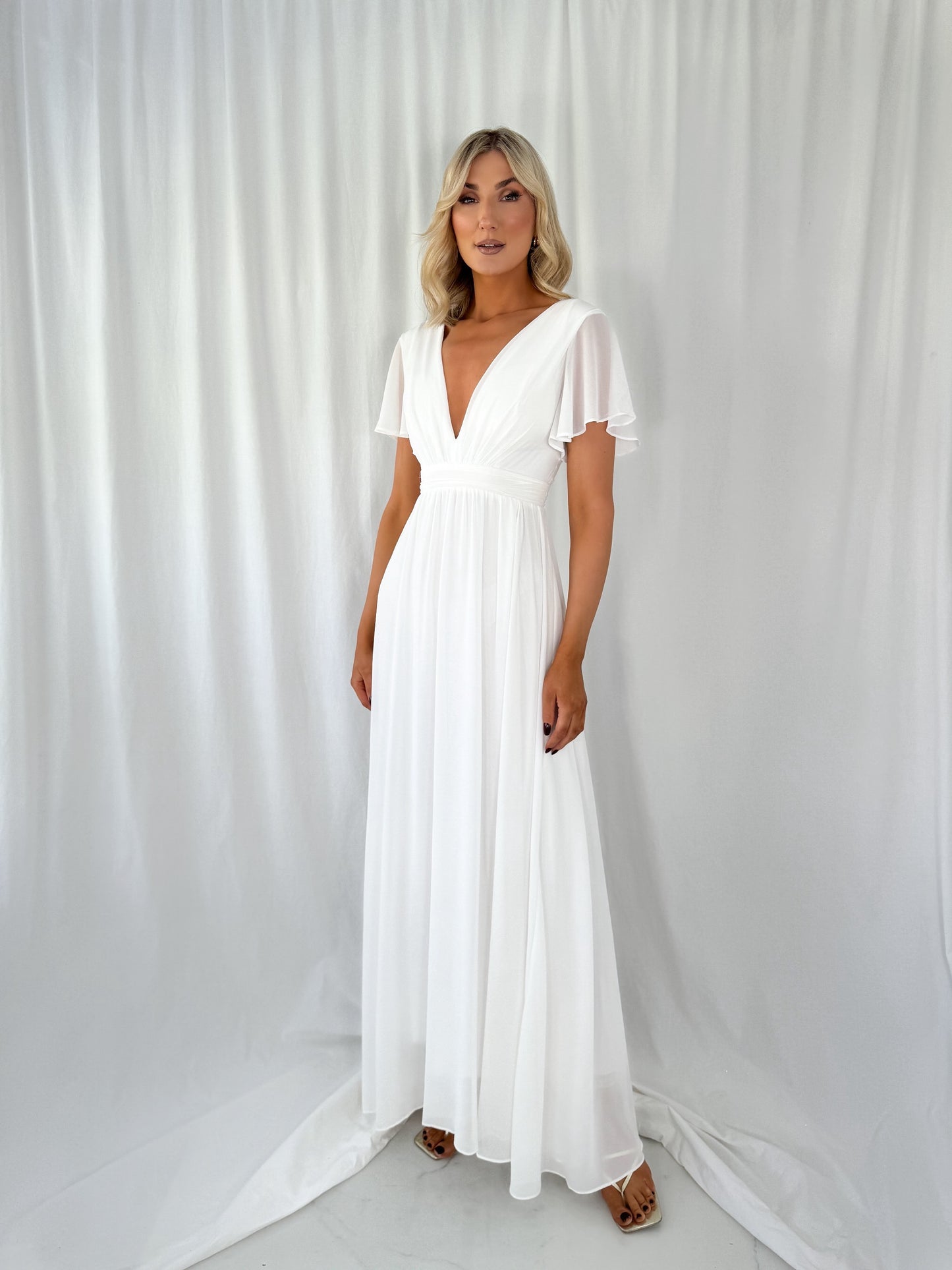 a woman in a white dress standing in a white dress