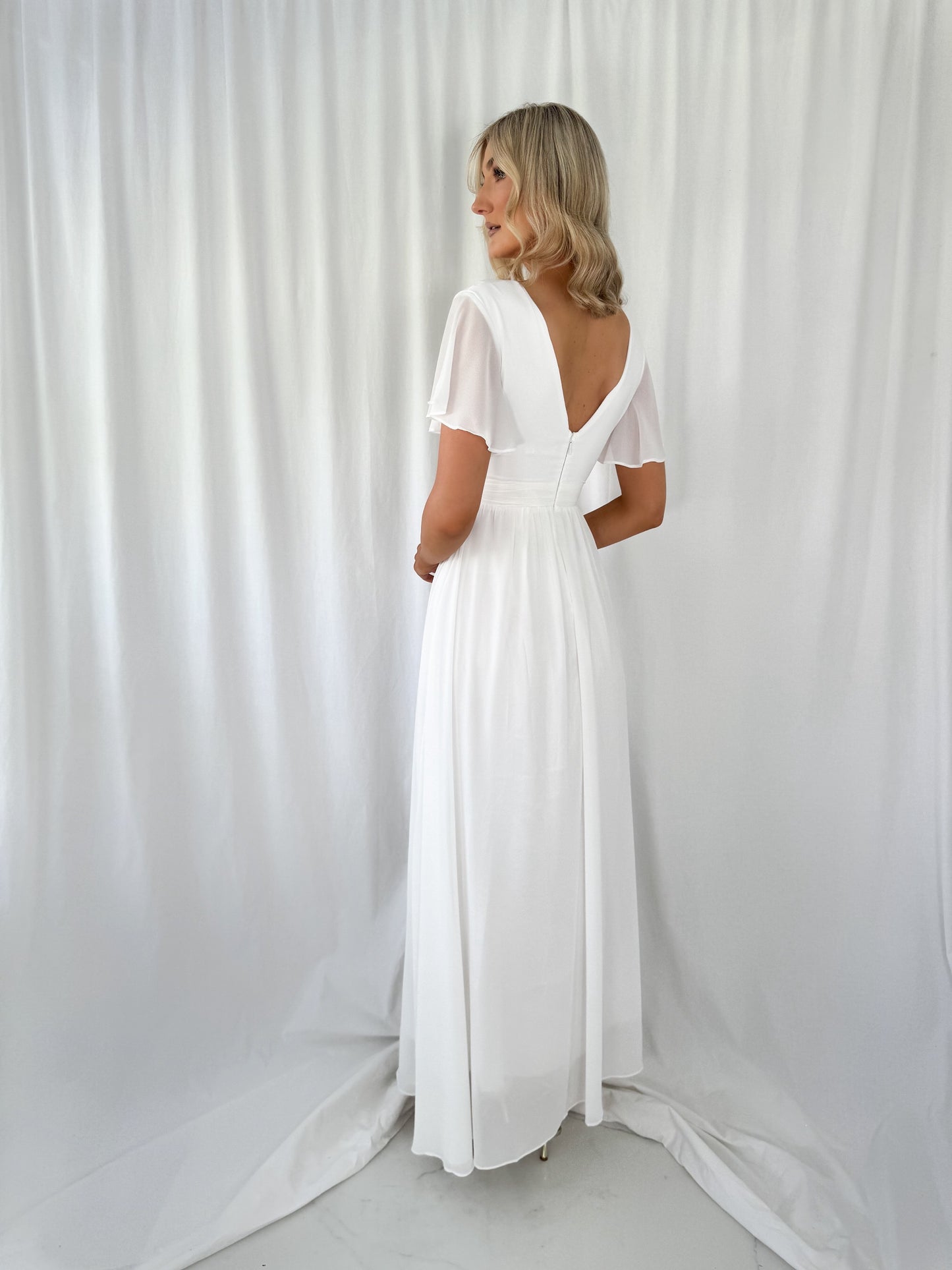 a woman in a white dress standing in a white dress