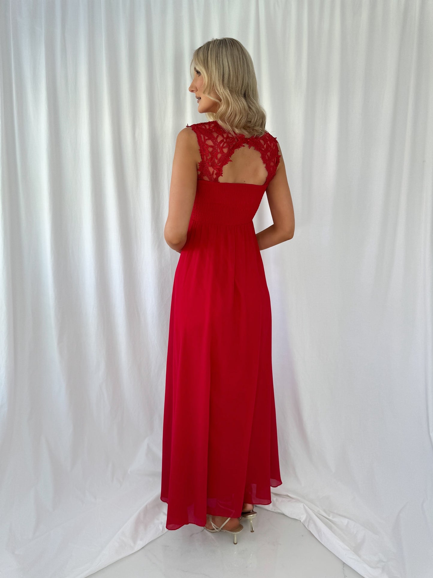 a woman in a red dress talking on a cell phone