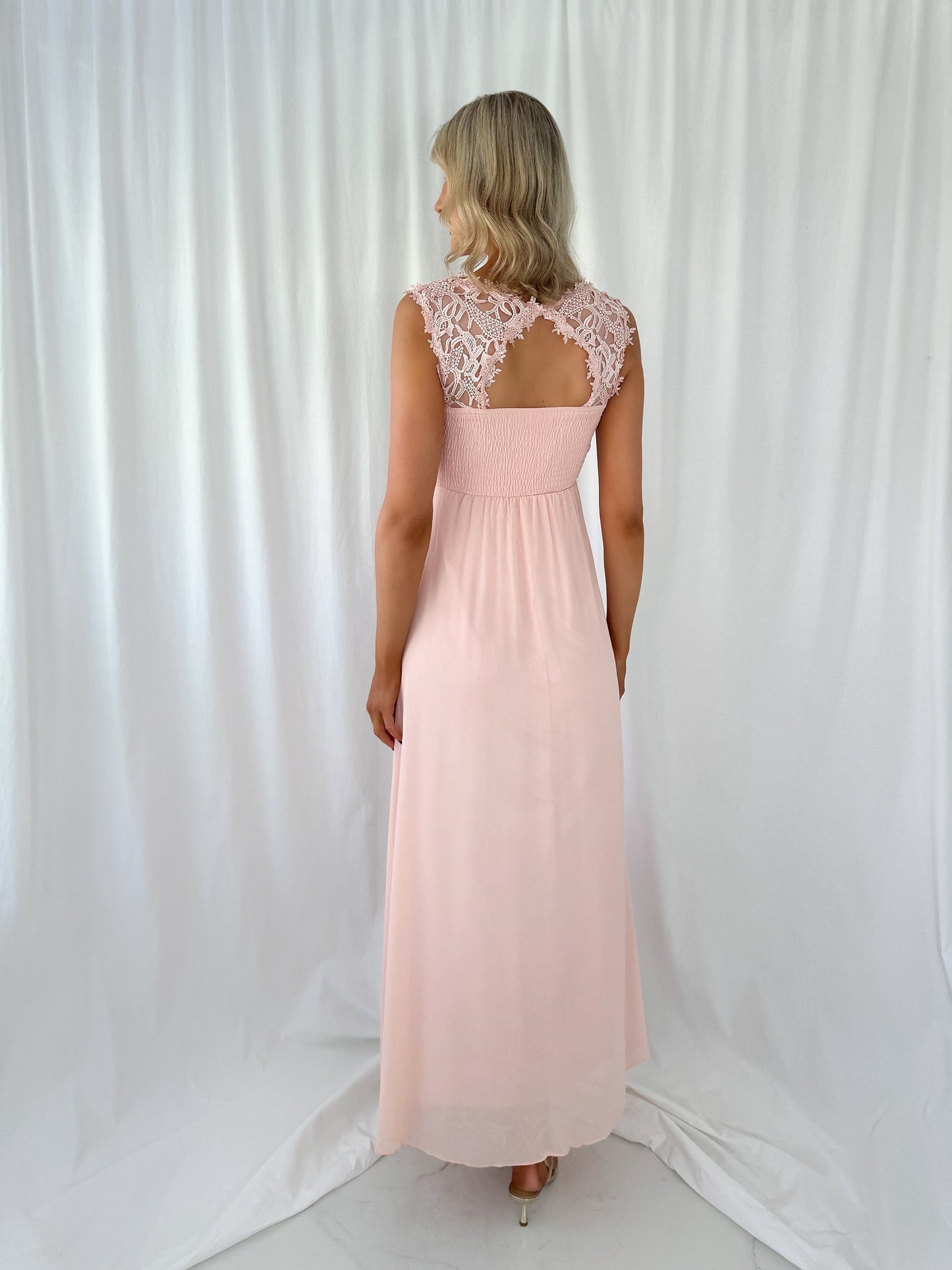 a woman in a pink dress holding a pink purse