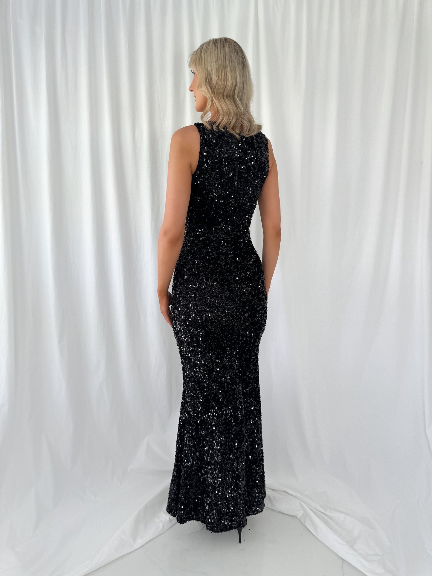a woman in a black dress standing in a white dress