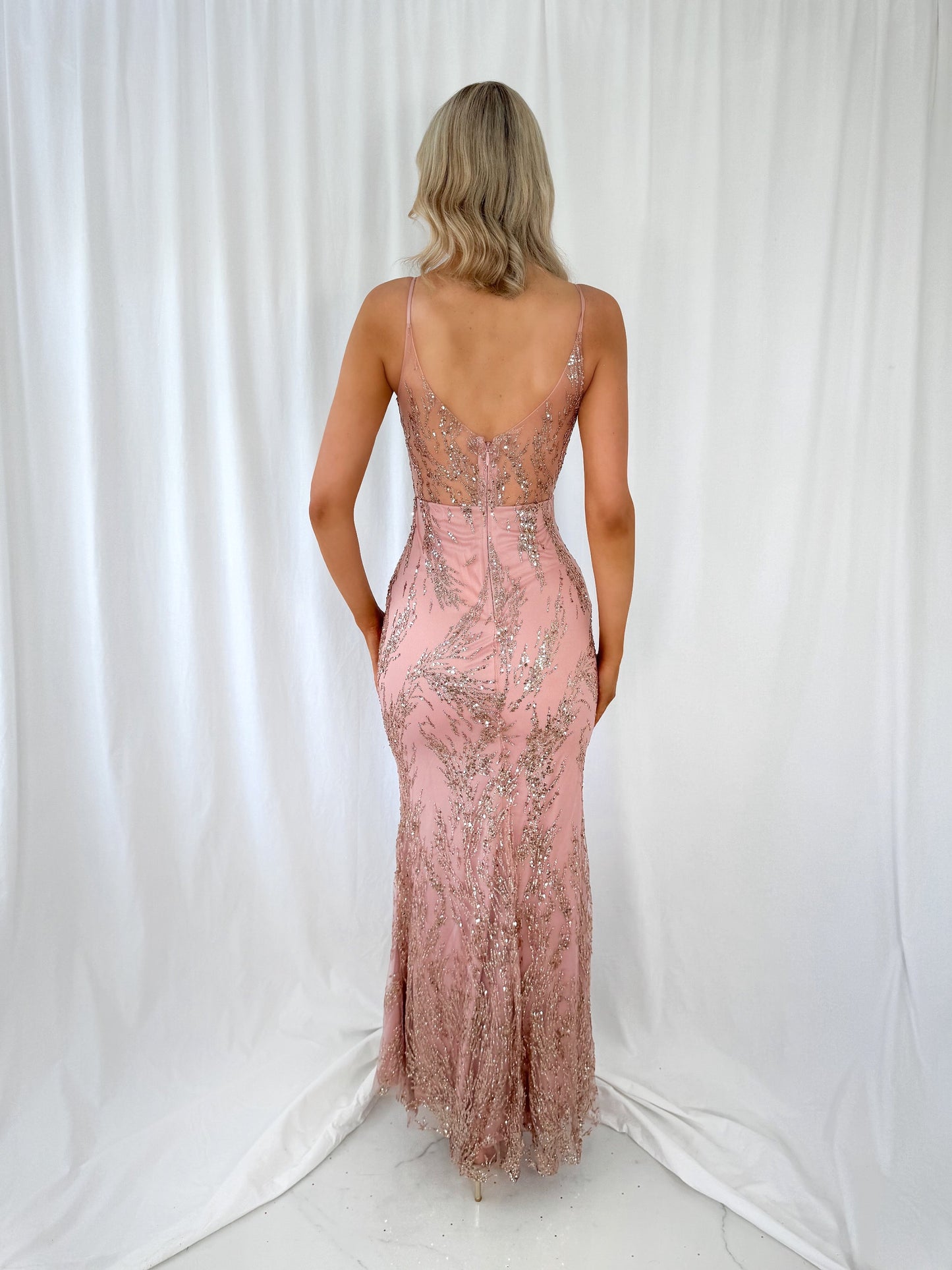 a woman in a pink dress holding a pink vase