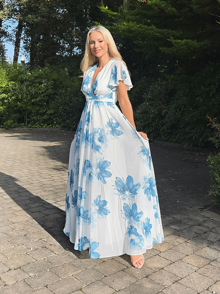 a woman in a dress standing in a park 