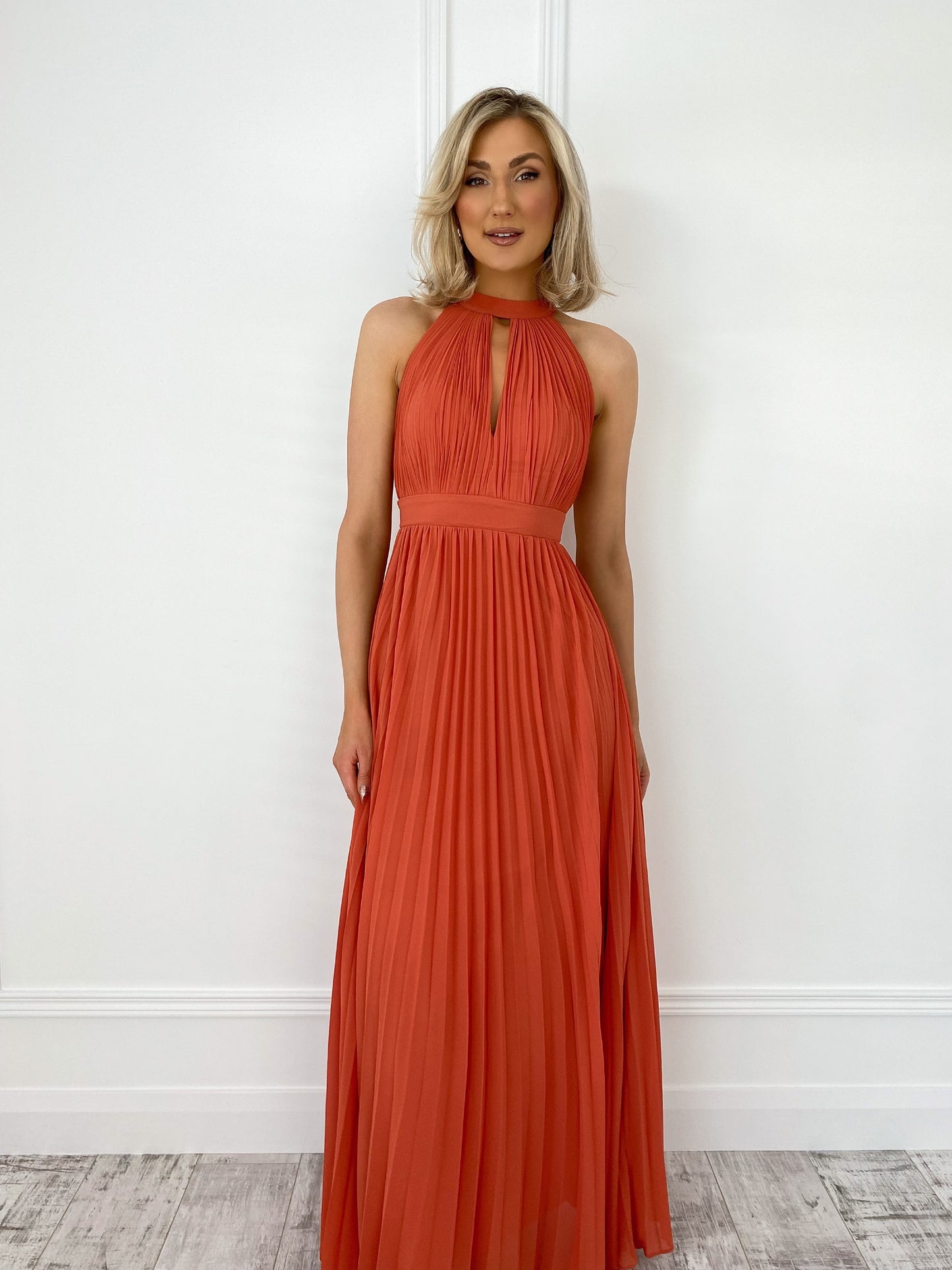 a woman in a red dress standing in front of a wall