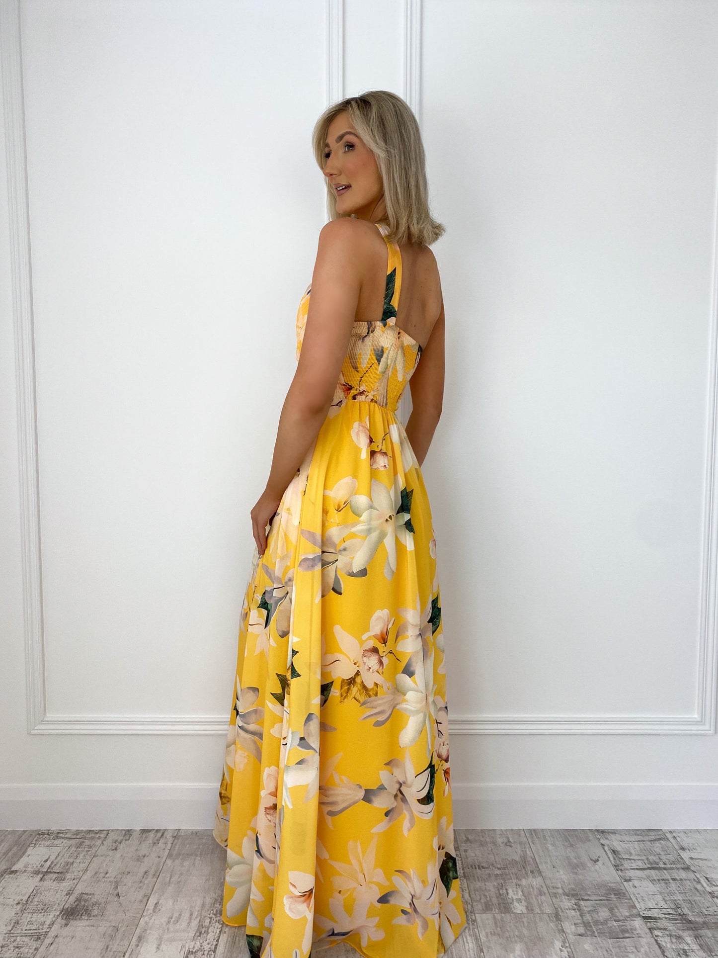 a woman in a yellow dress holding a cell phone 