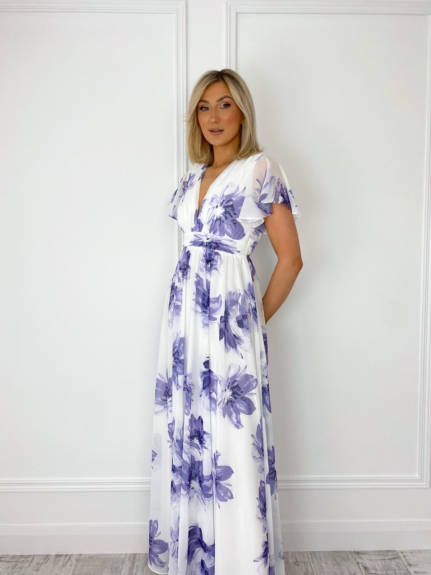 a woman in a dress standing in a bathroom