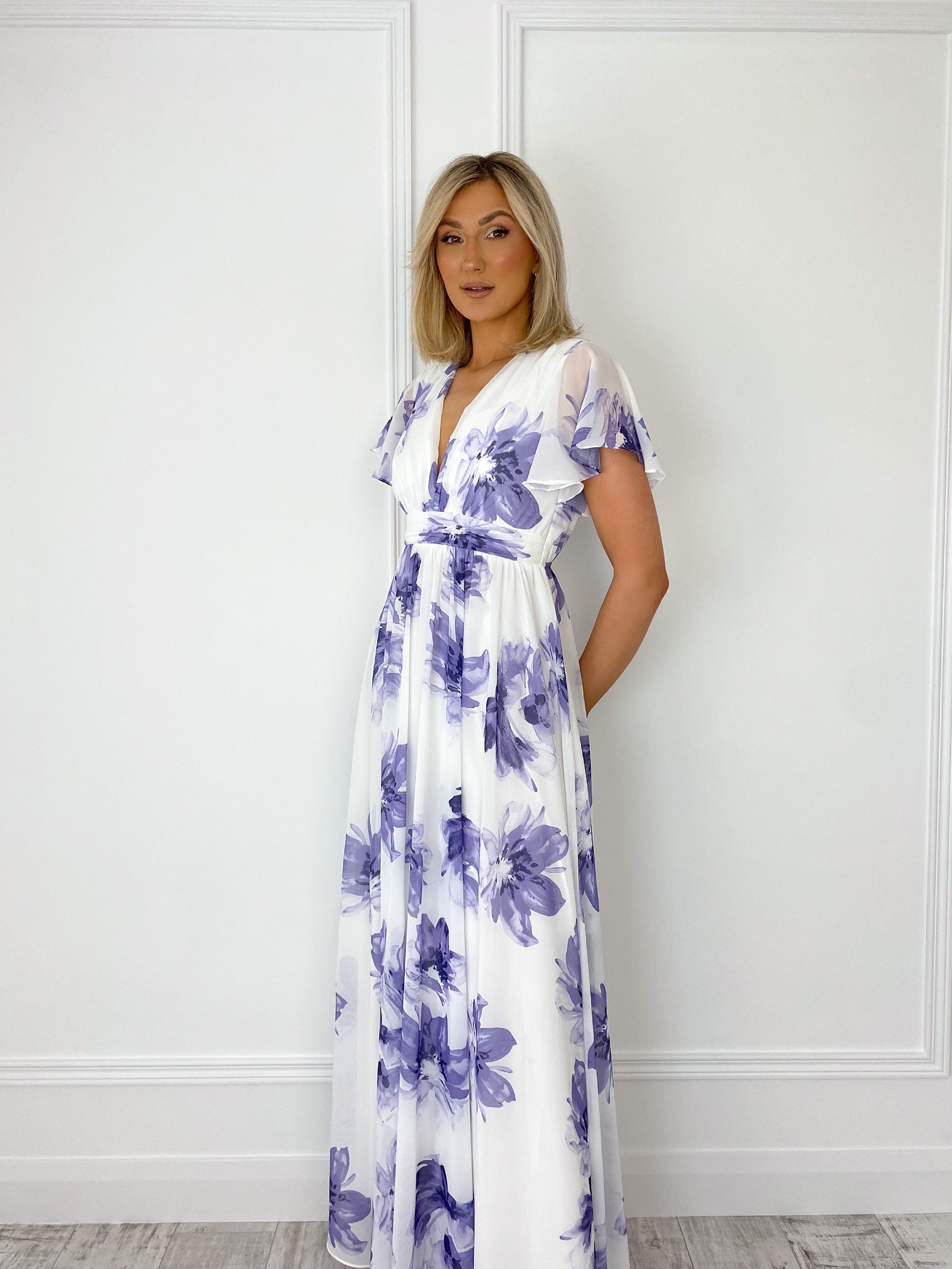 a woman in a dress standing in a bathroom