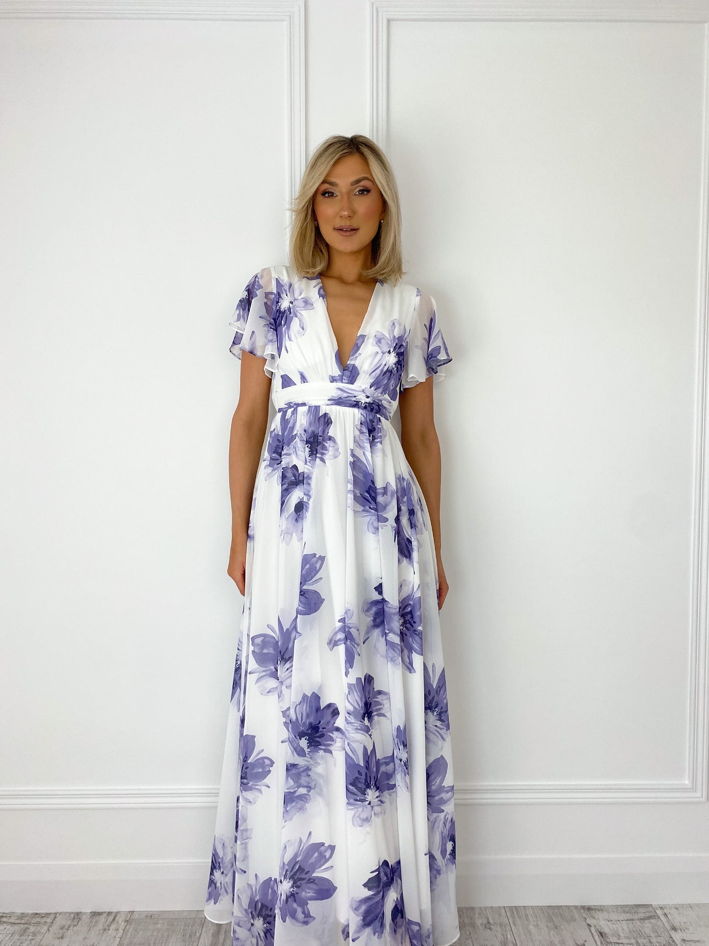 a woman in a white dress standing in front of a door