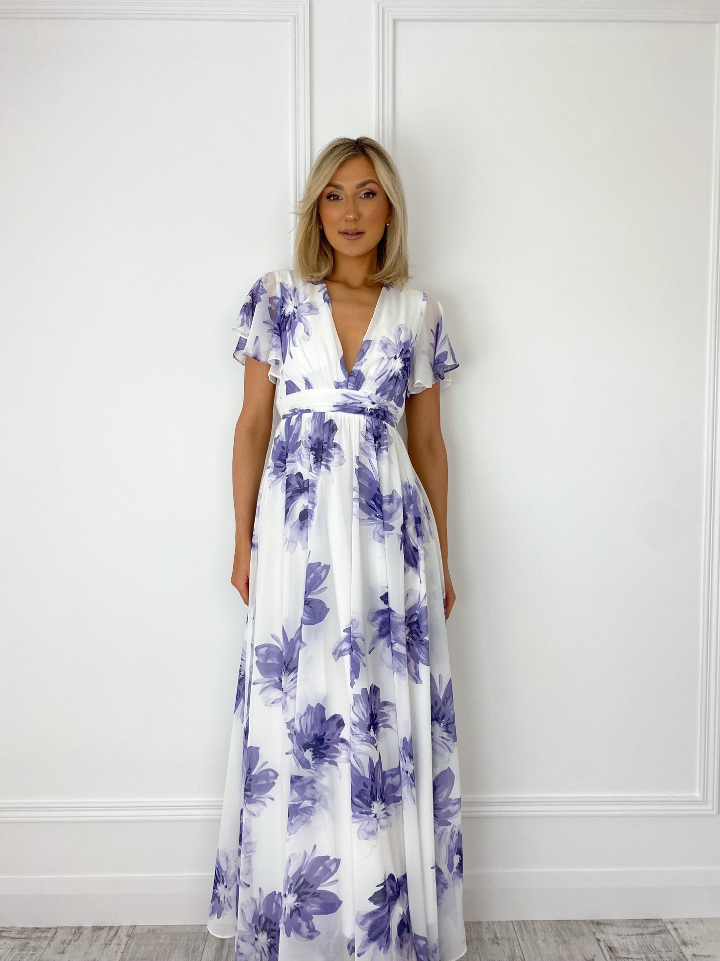 a woman in a white dress standing in front of a door 